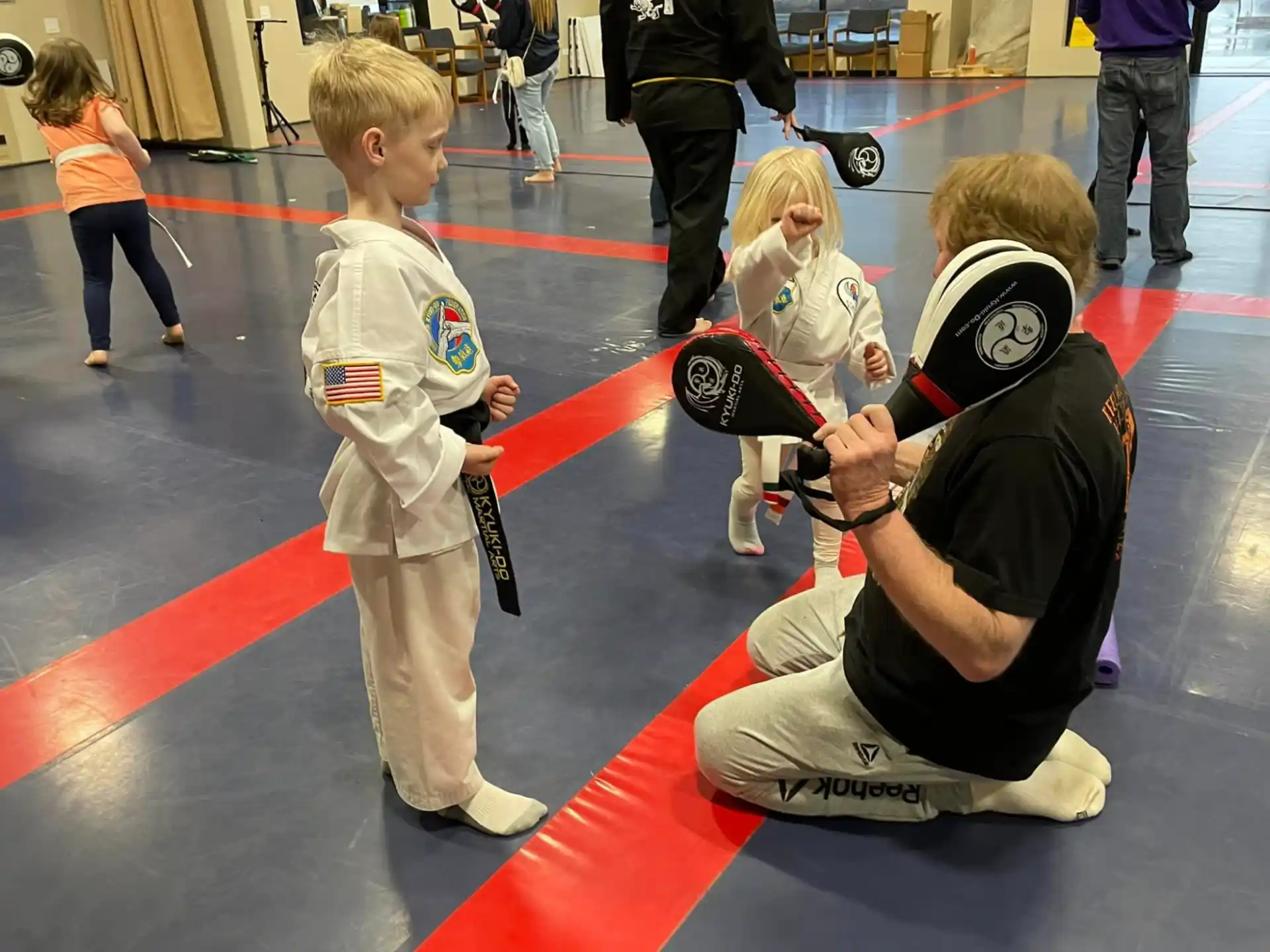 a person and a couple children in a gym