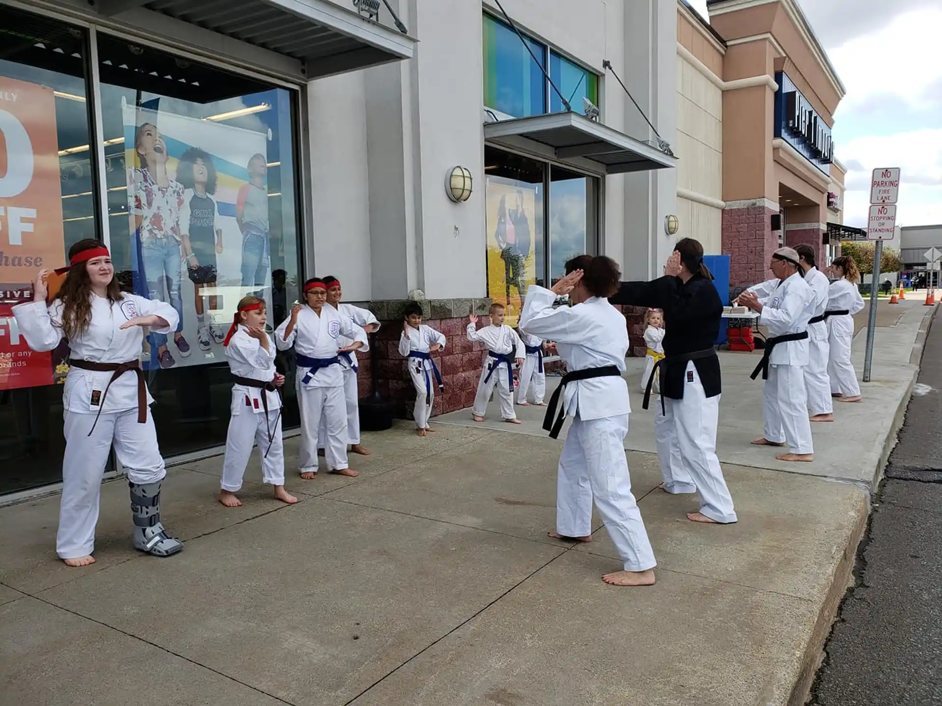 a group of people in white karate uniforms on a street