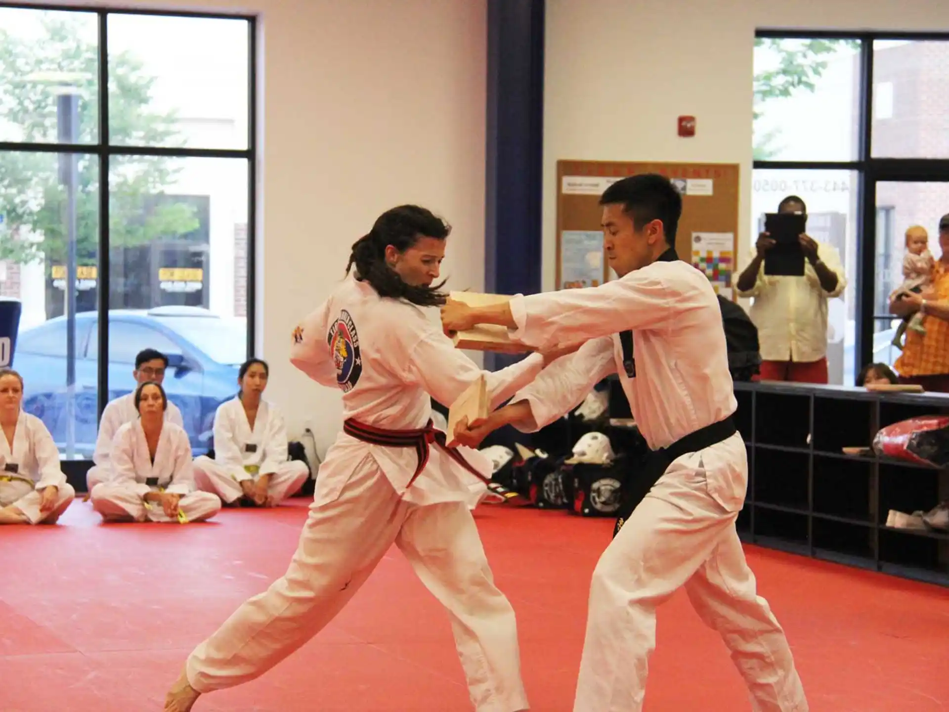 a man and a woman in karate uniforms in a room with other people