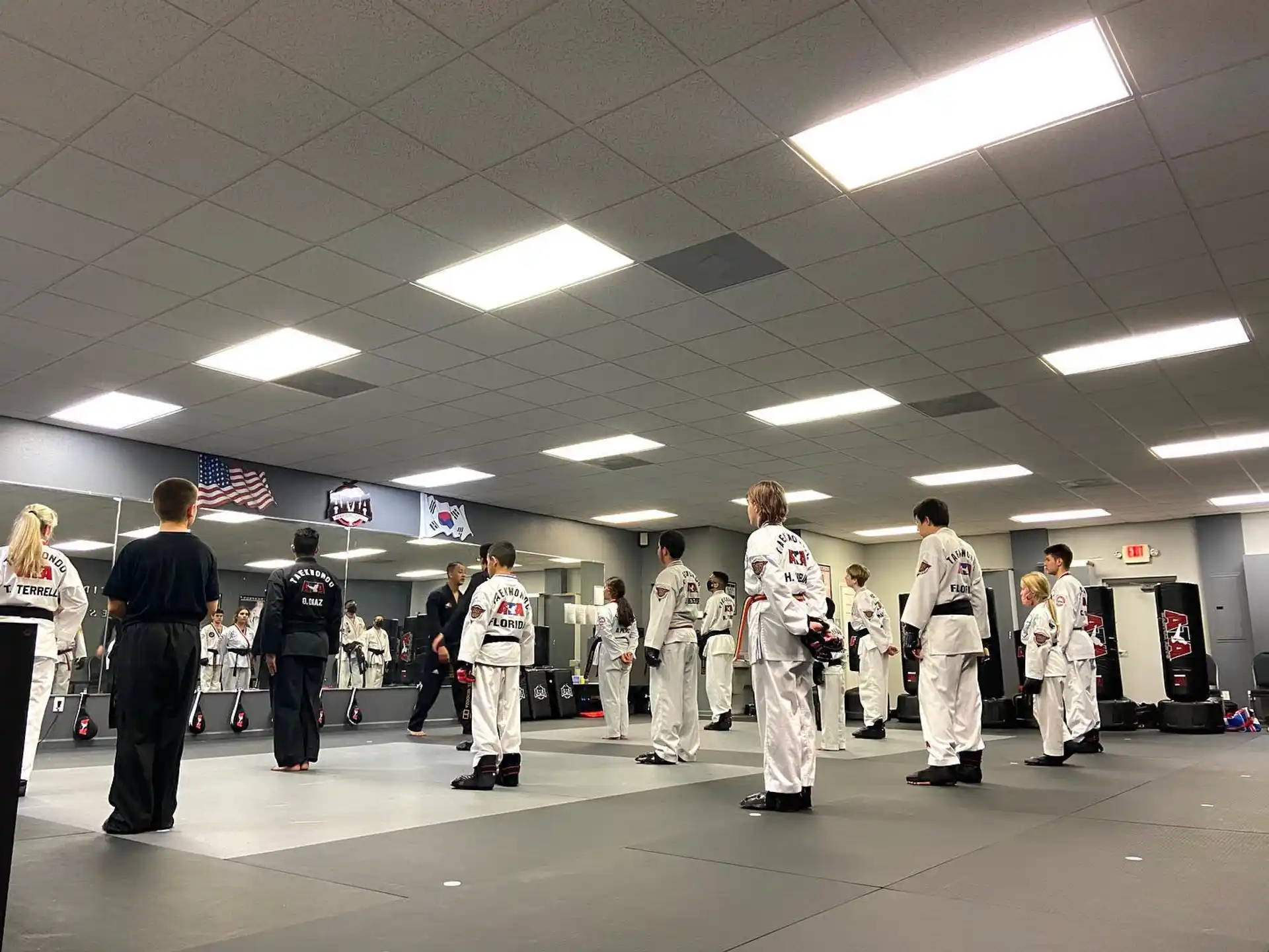 a group of people in white uniforms standing in a room with flags