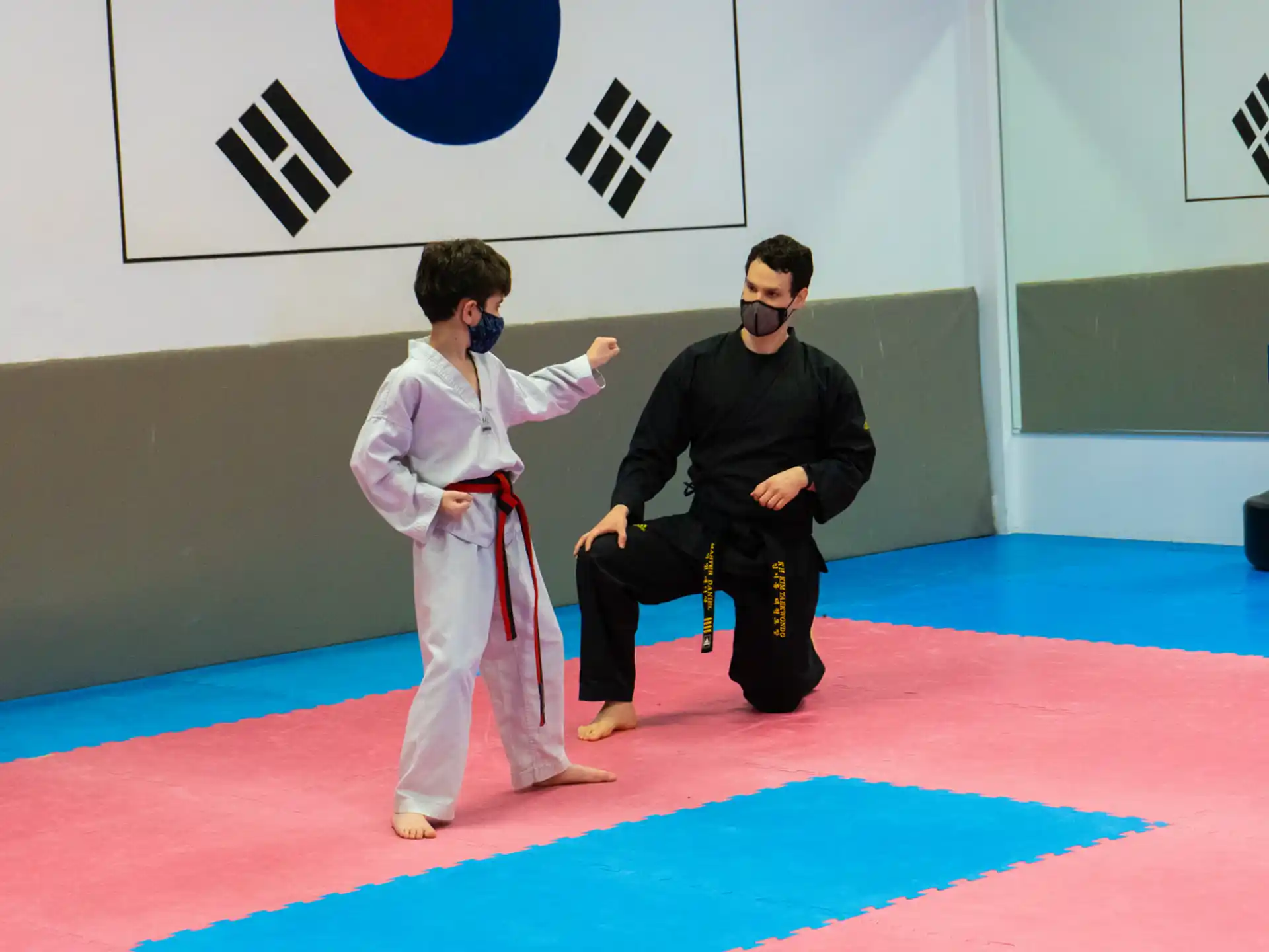 a person in a karate uniform and a person in a black shirt