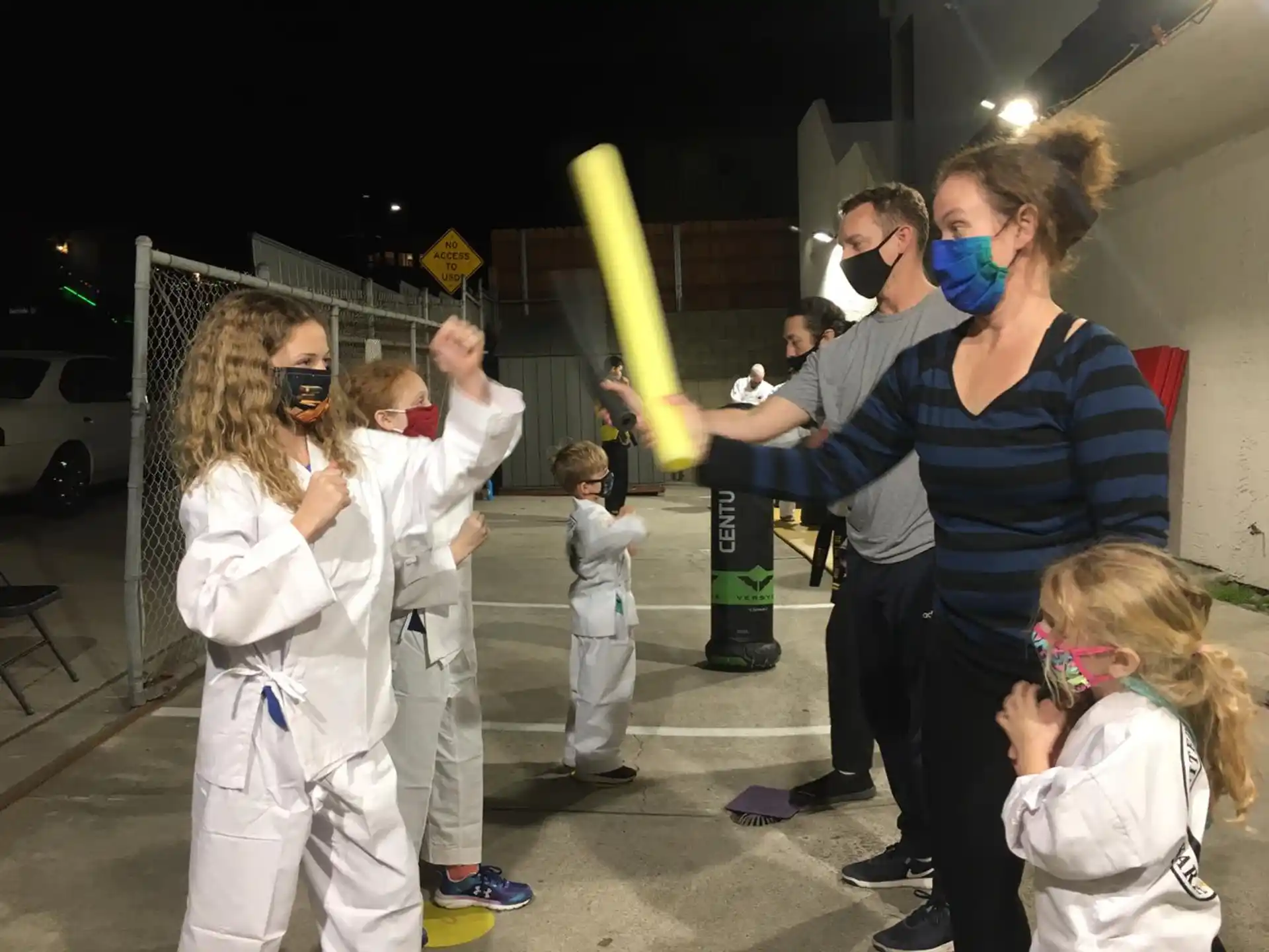 a group of people wearing masks and holding a bat