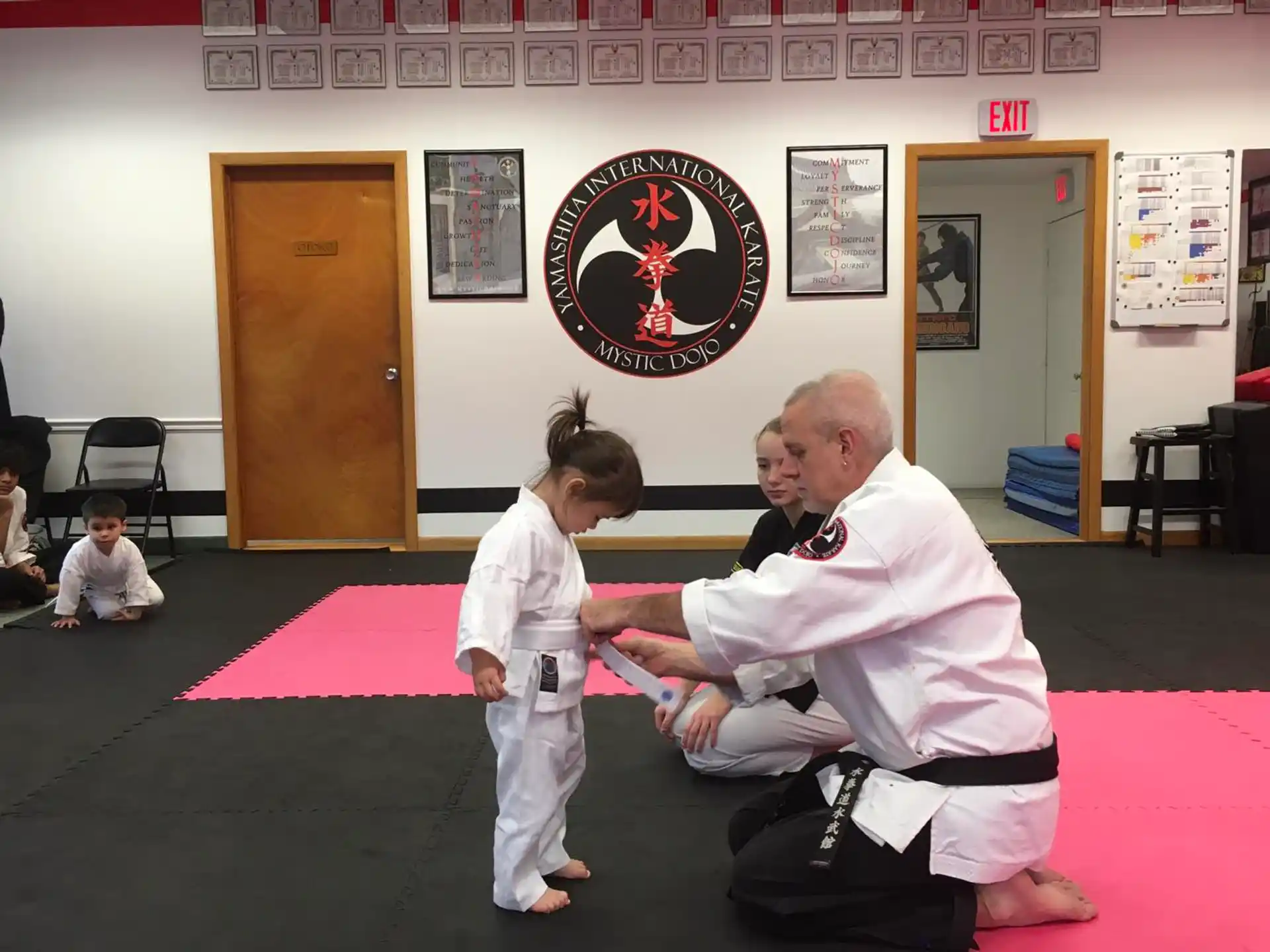 a person and a girl in a karate uniform