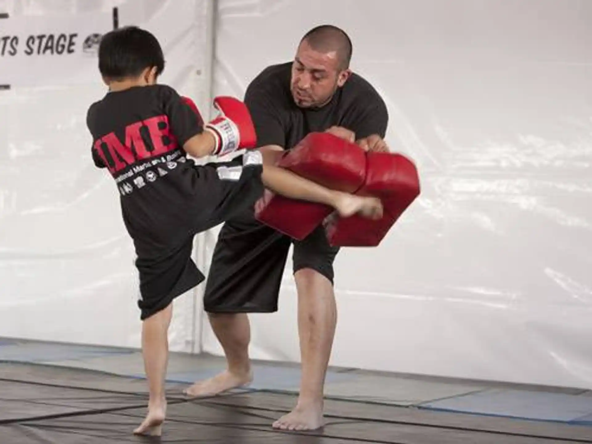 a man holding a boy in a boxing ring