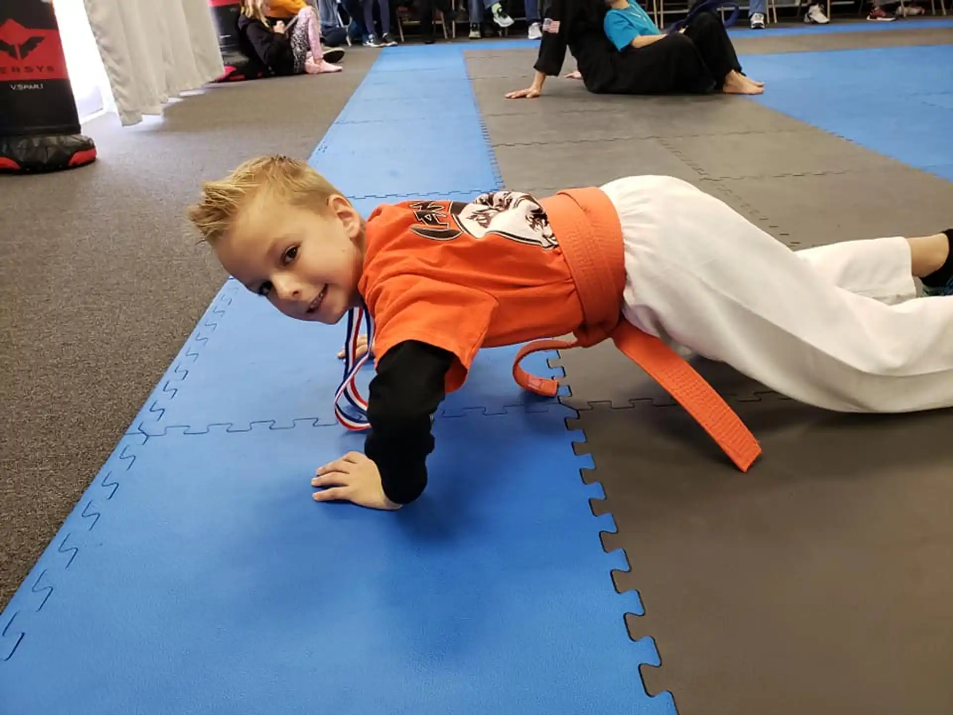 a boy doing a plank on a mat