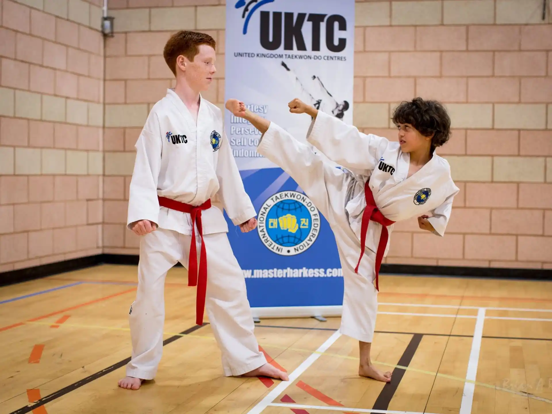 a man and a woman in karate uniforms holding a flag