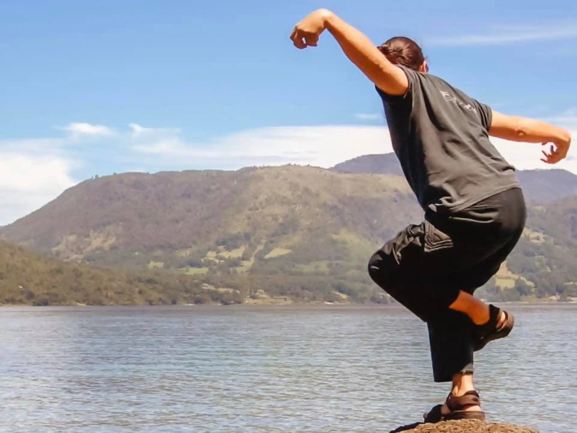 a man jumping off a rock into the water