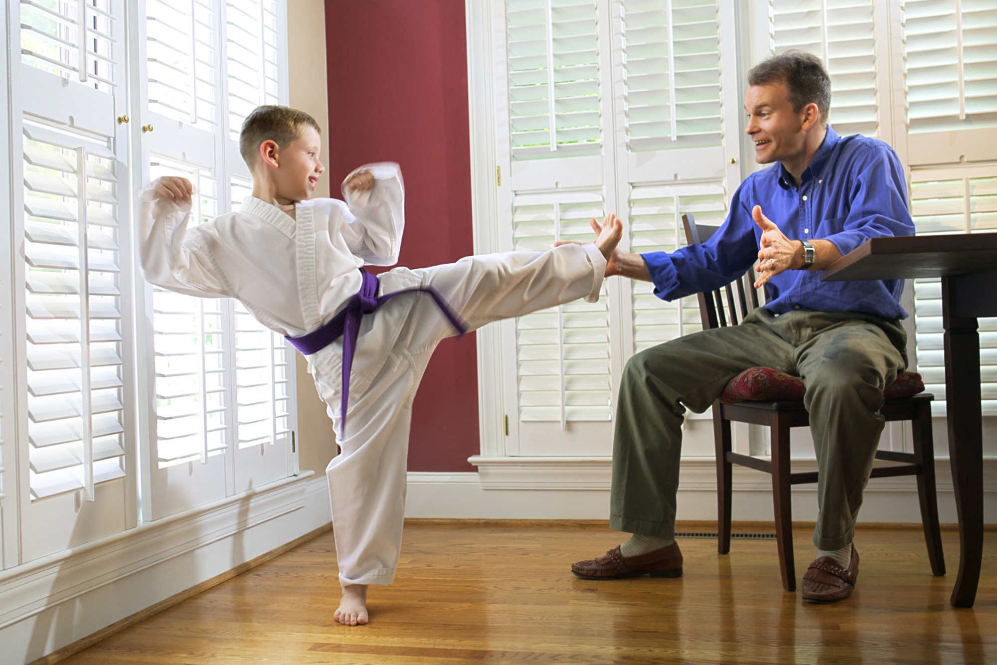 a person in a white suit kicking a person in a blue shirt