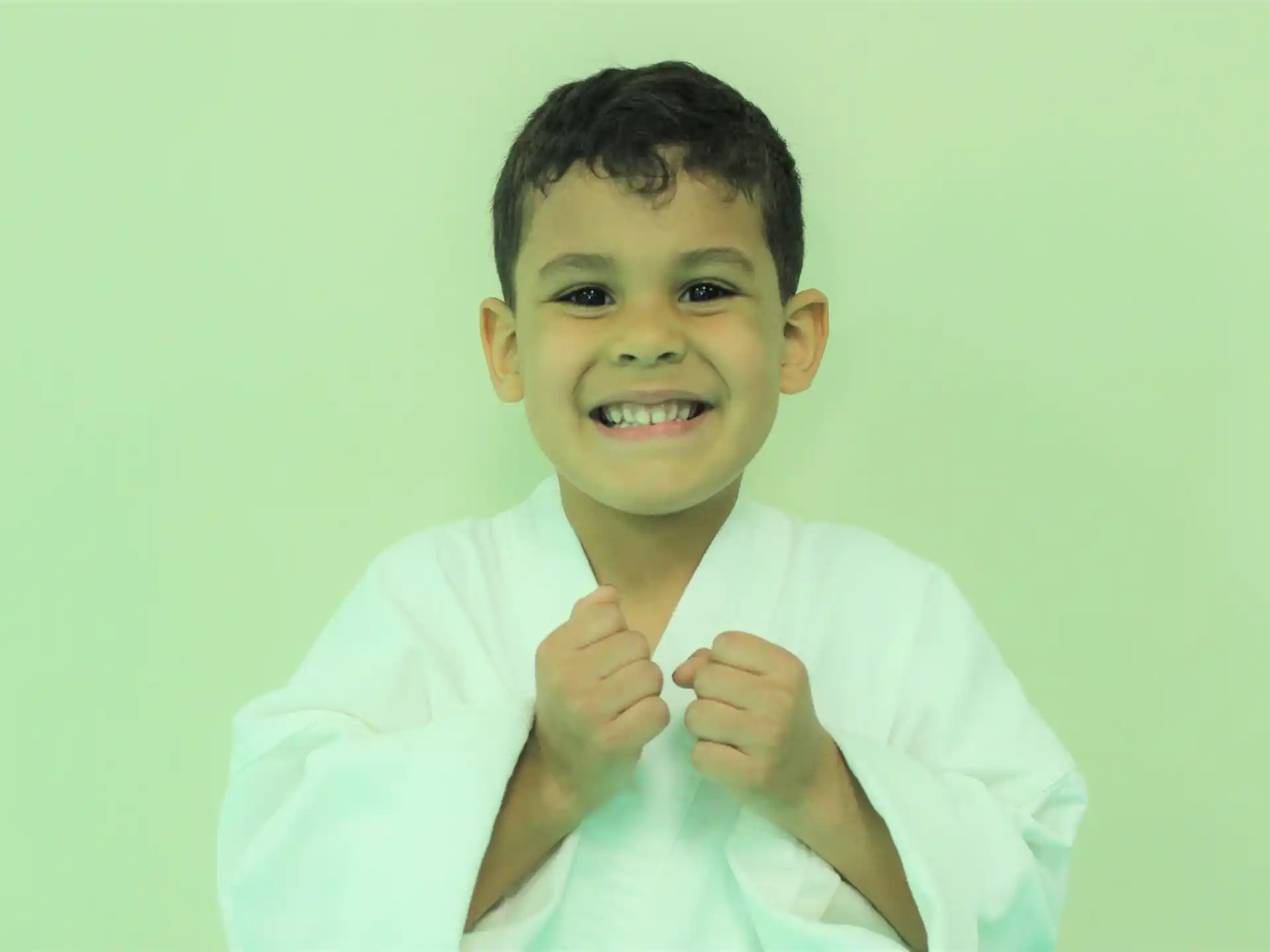 a boy smiling and holding his hands together
