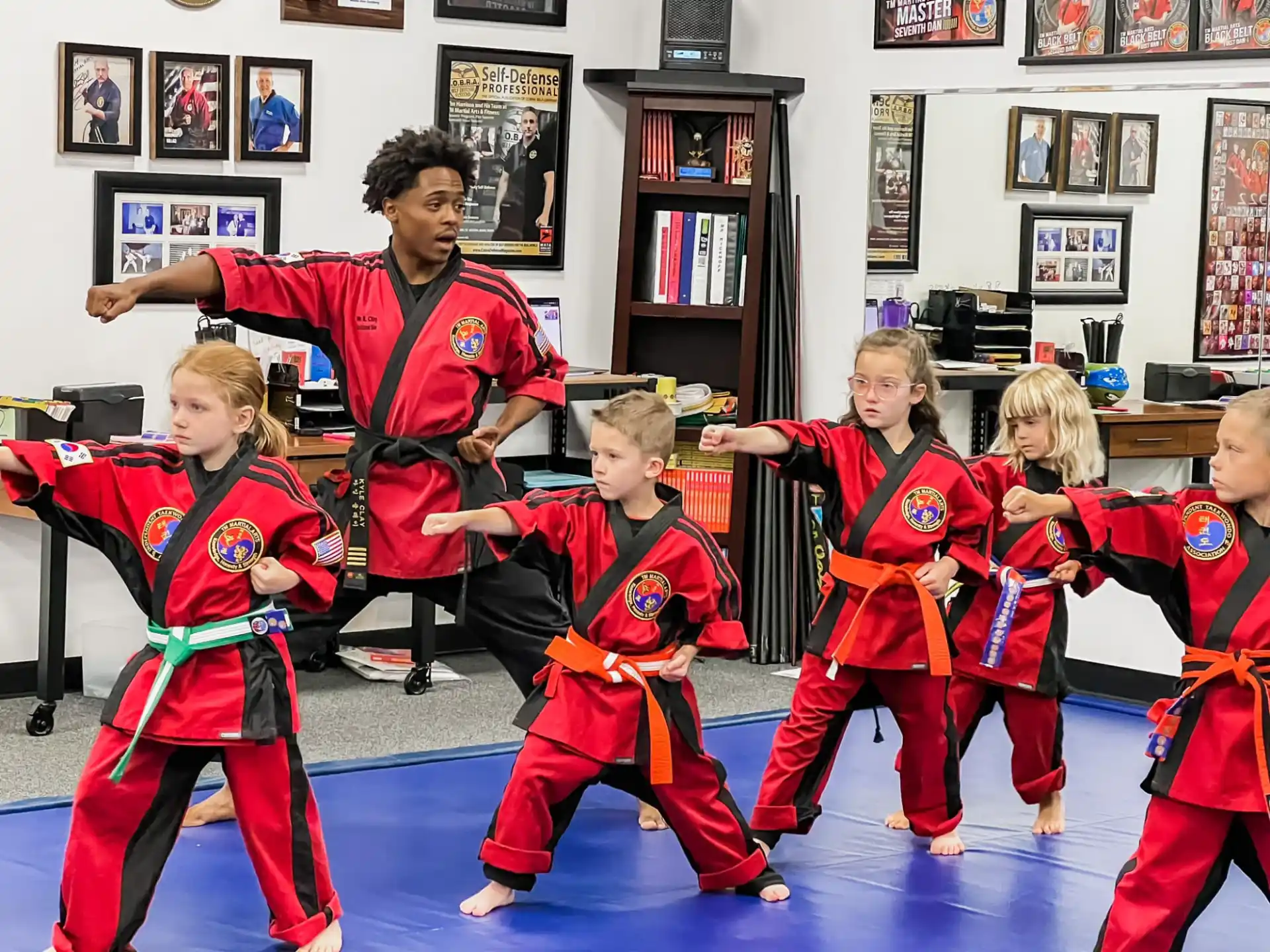 a group of children in red and black uniforms in a room