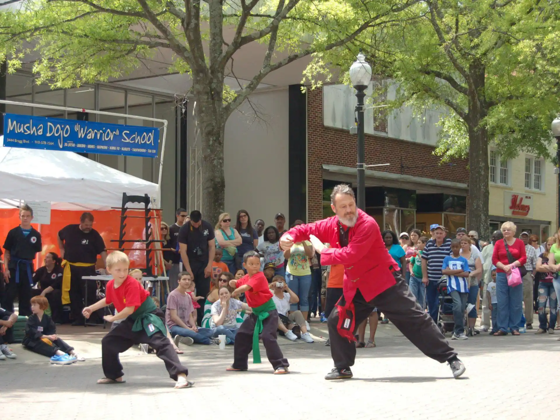 a person in red shirt and black pants running with a group of people watching