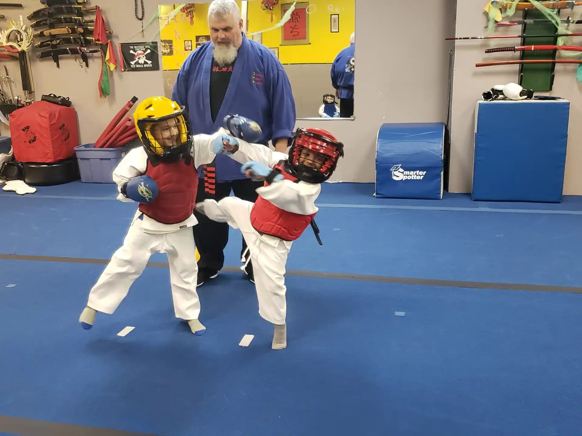 a person and two kids in a room with helmets