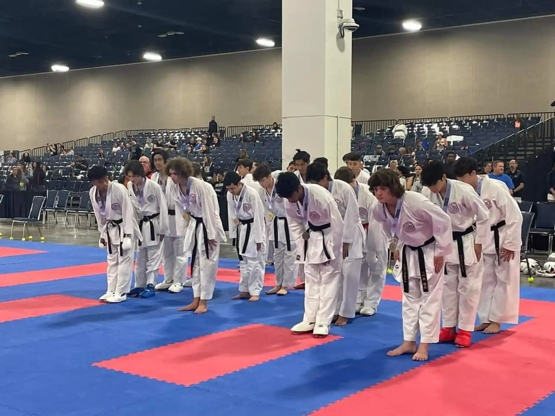 a group of people in white karate uniforms standing on a mat