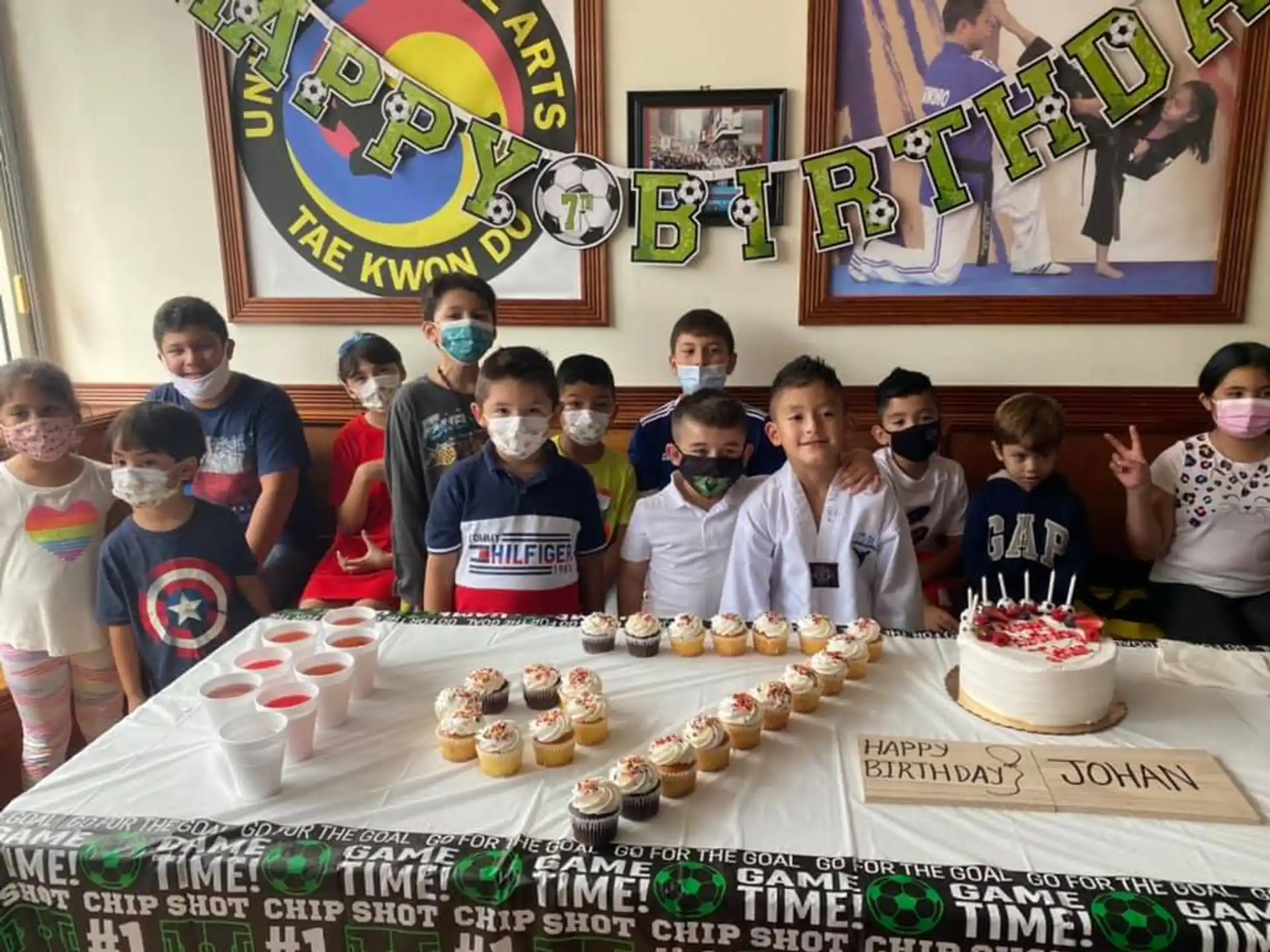 a group of people posing for a photo with a cake