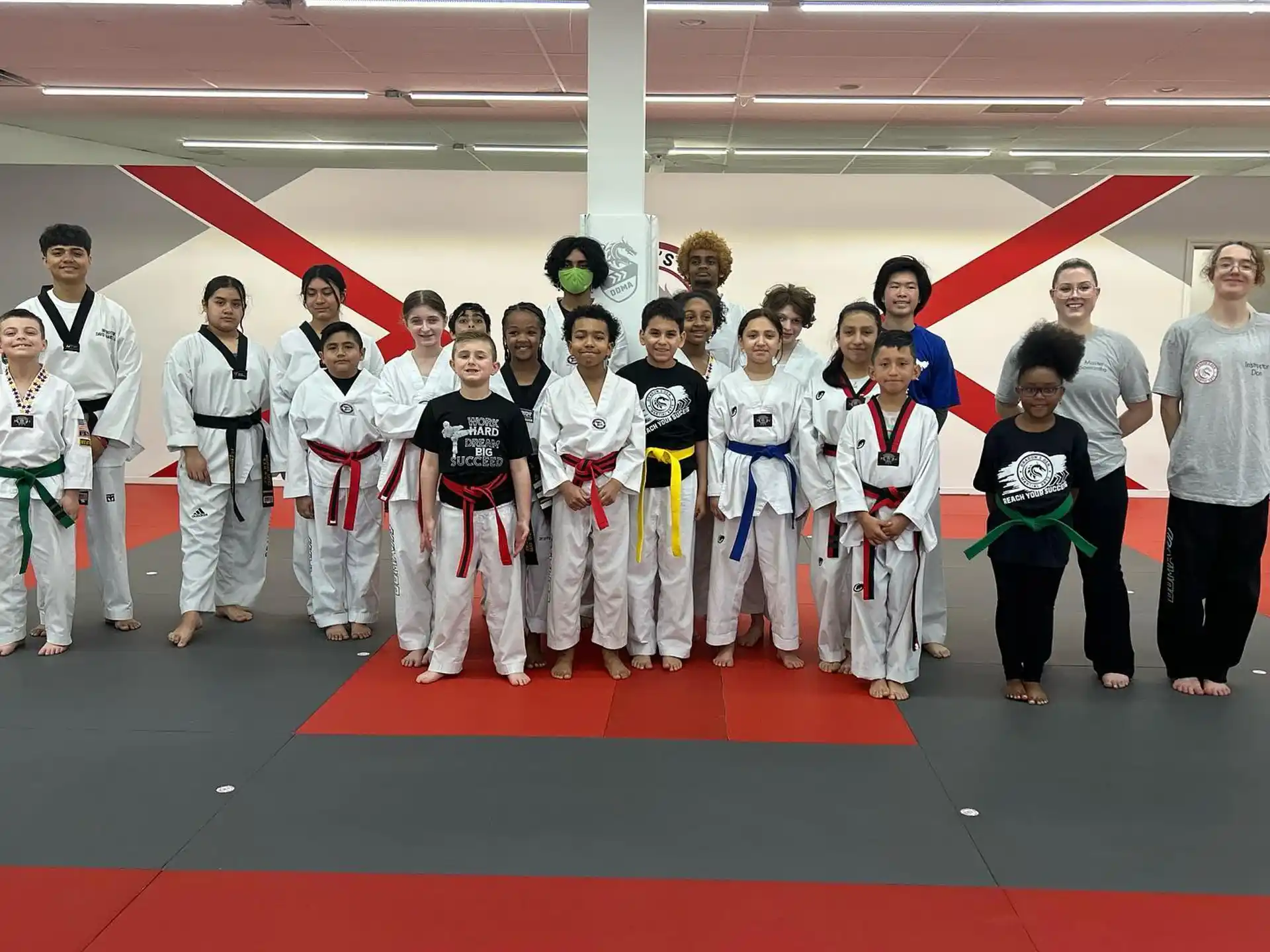 a group of people in white karate uniforms posing for a photo