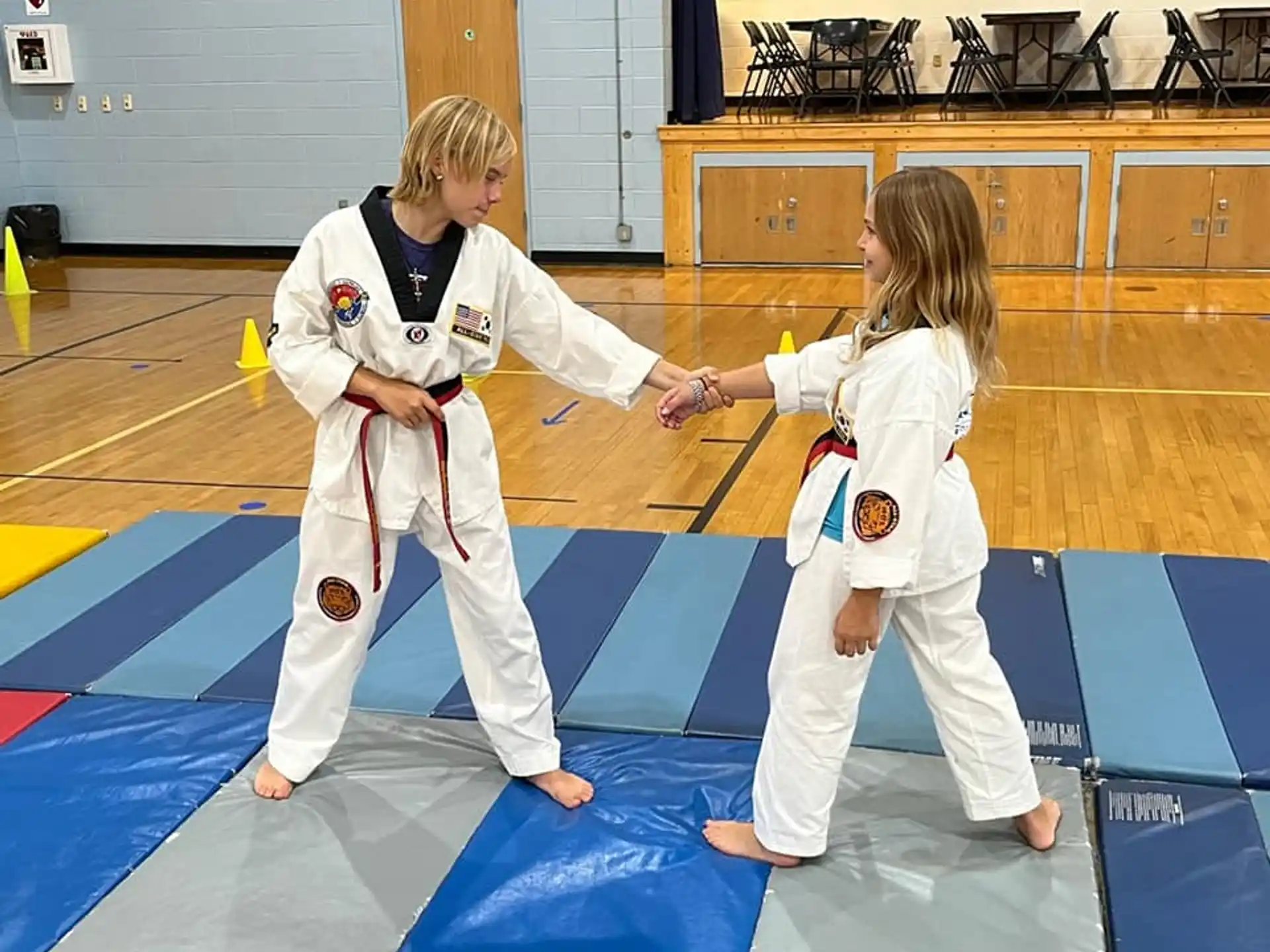 a couple of girls in karate uniforms