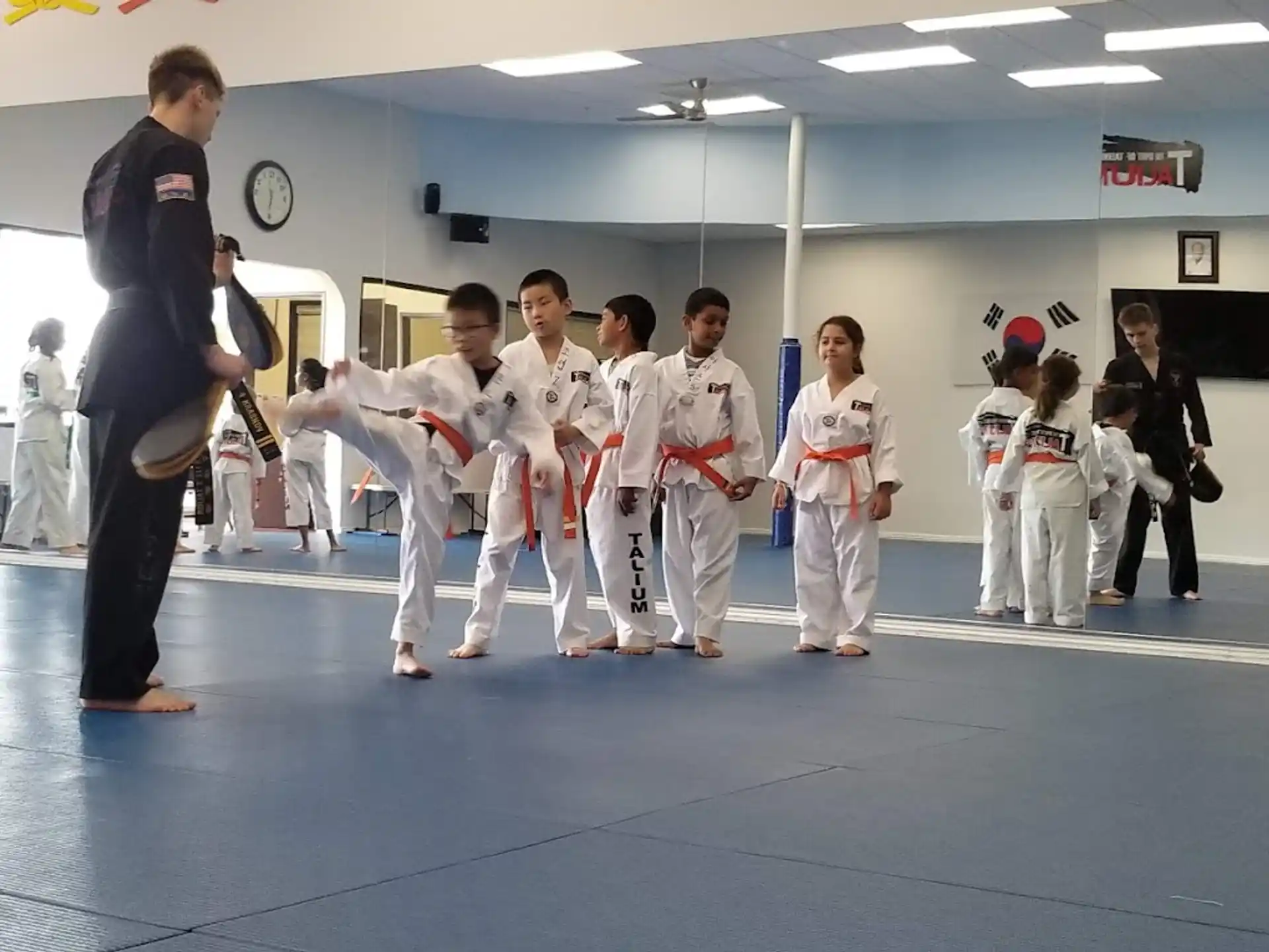 a person standing in front of a group of people in karate uniforms