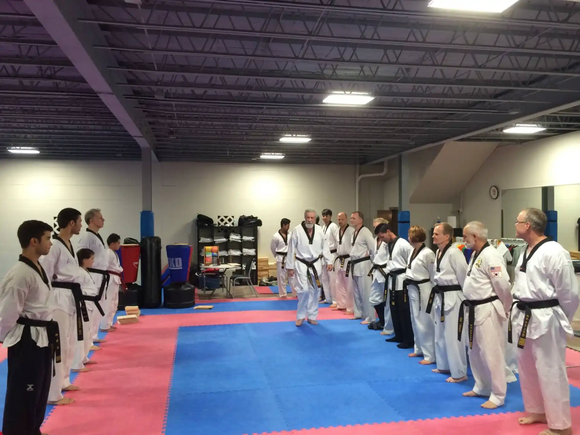 a group of people in white karate uniforms standing in a room
