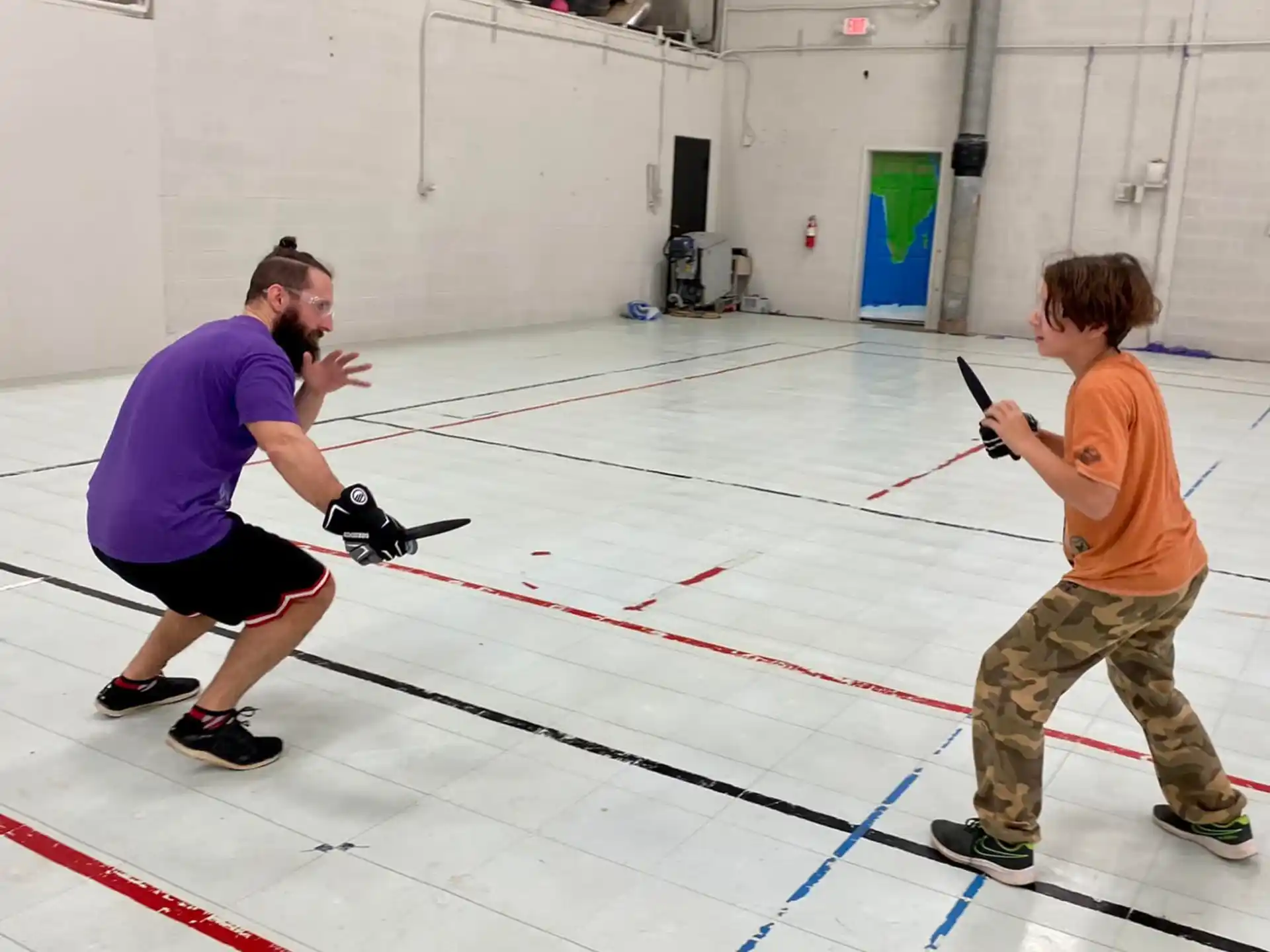 a man and a boy shooting a bow and arrow