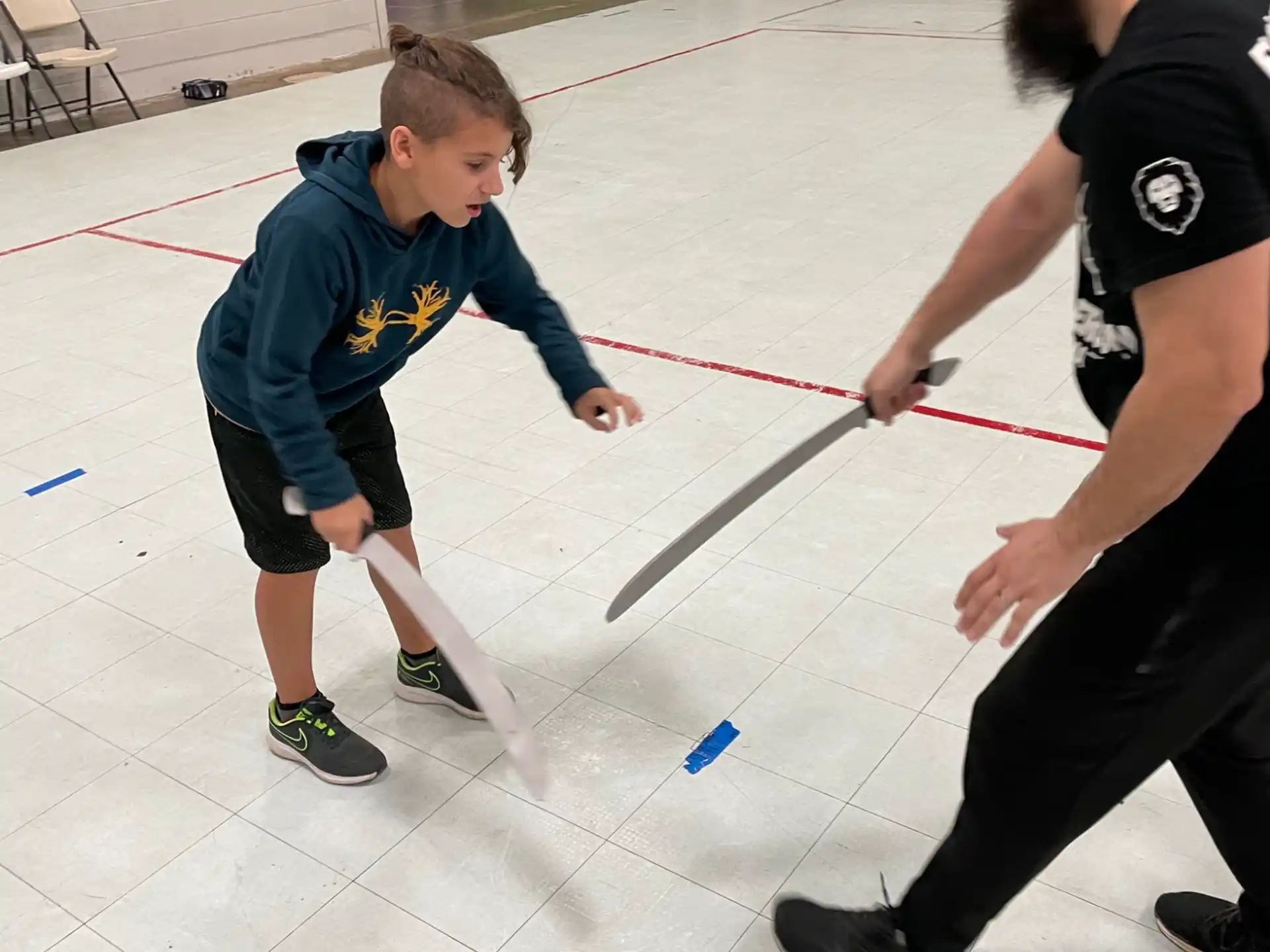 a person and a boy playing with a toy sword
