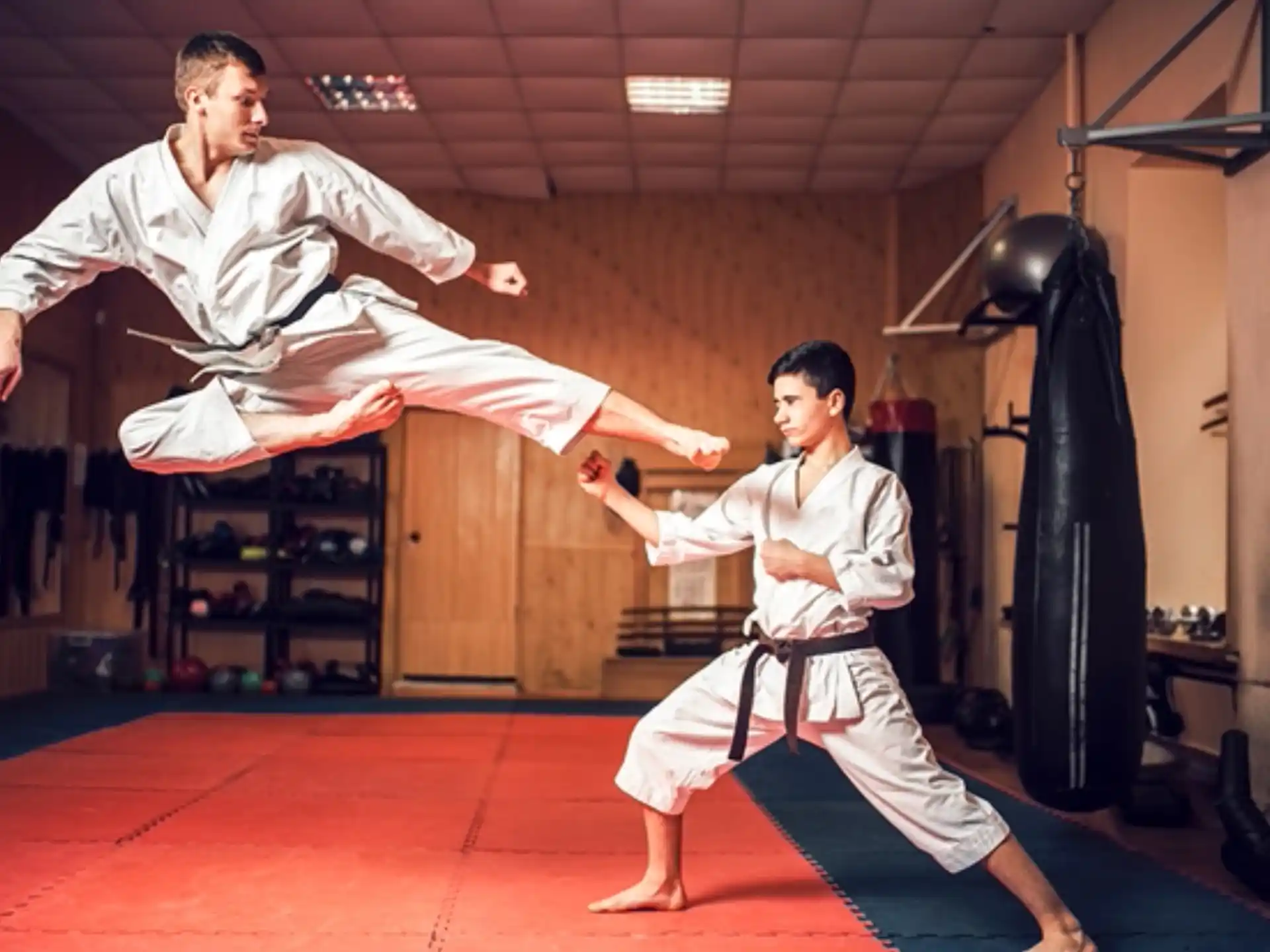 a person and a boy in karate uniforms in a room
