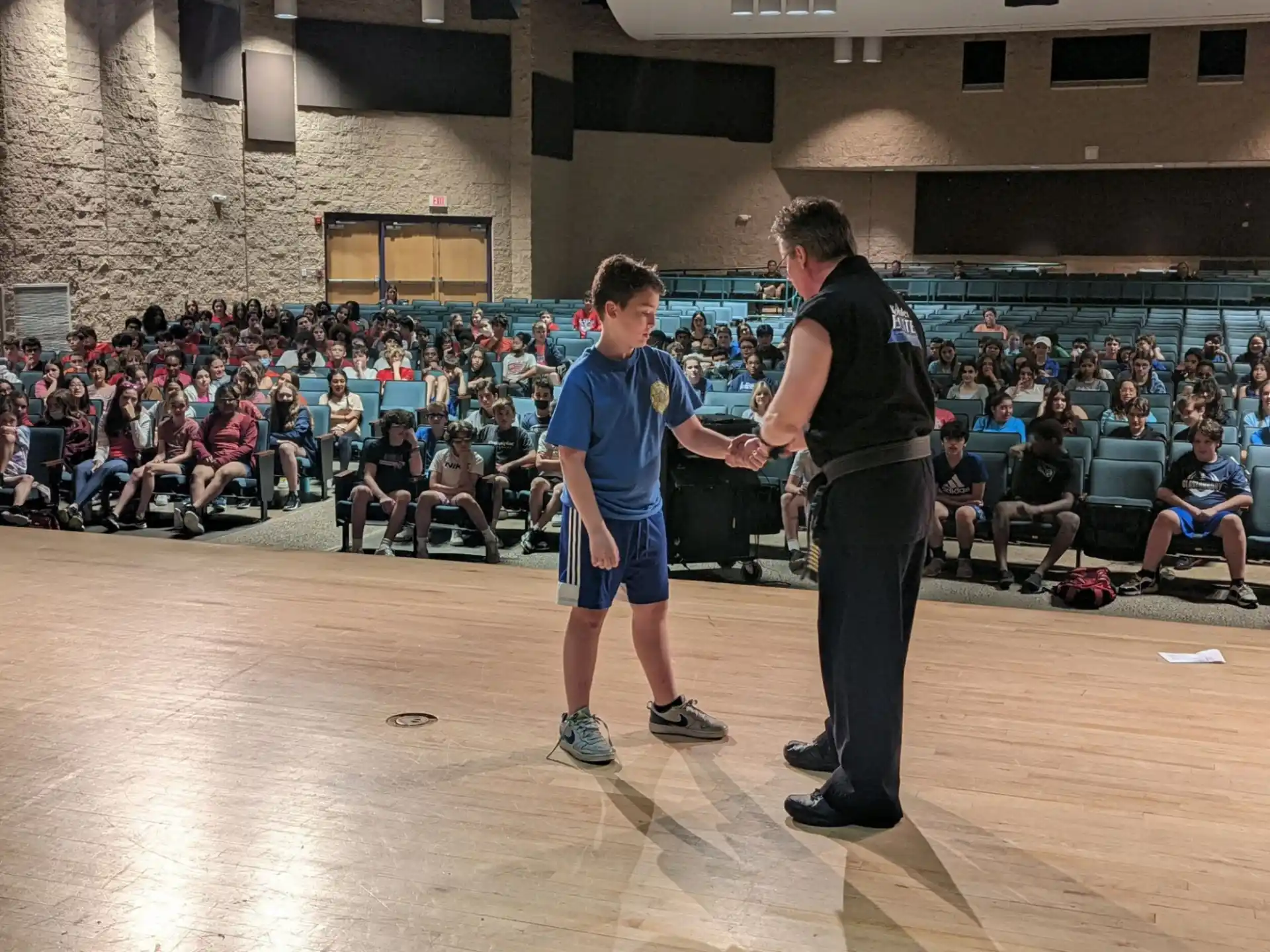 a person and a boy playing a sport in front of a crowd