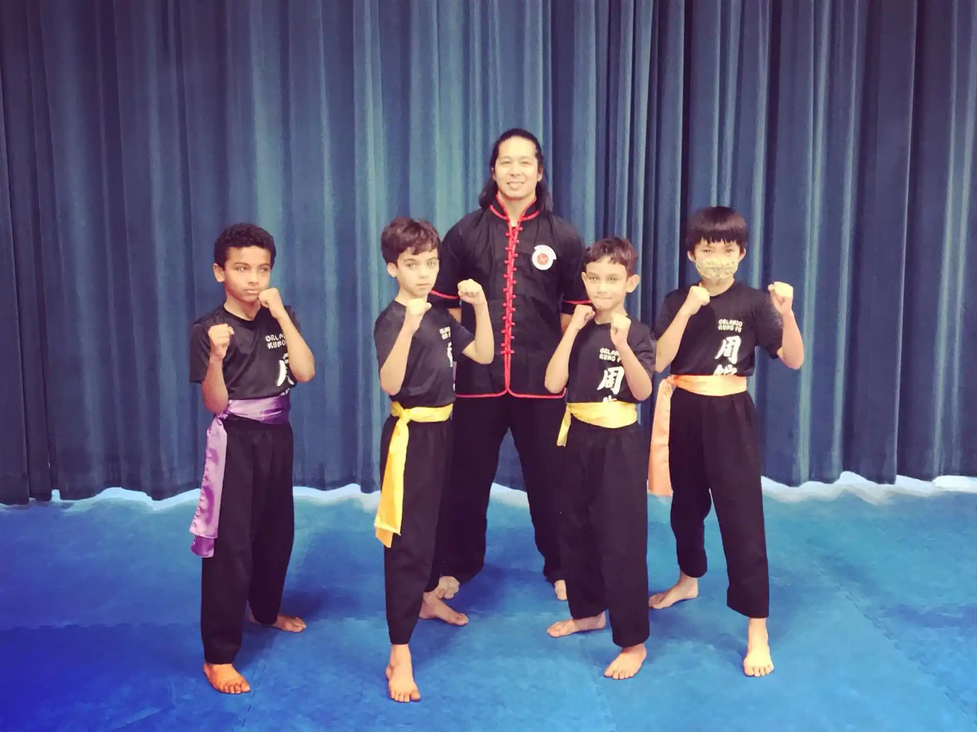 a group of kids in martial arts uniforms posing for a photo