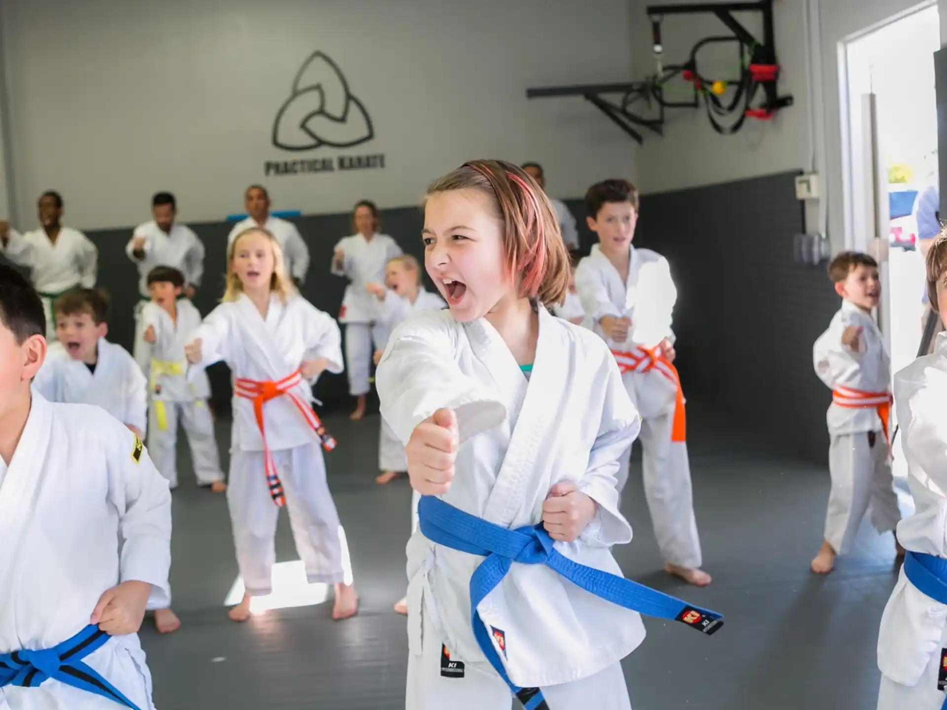 a group of children in white karate uniforms
