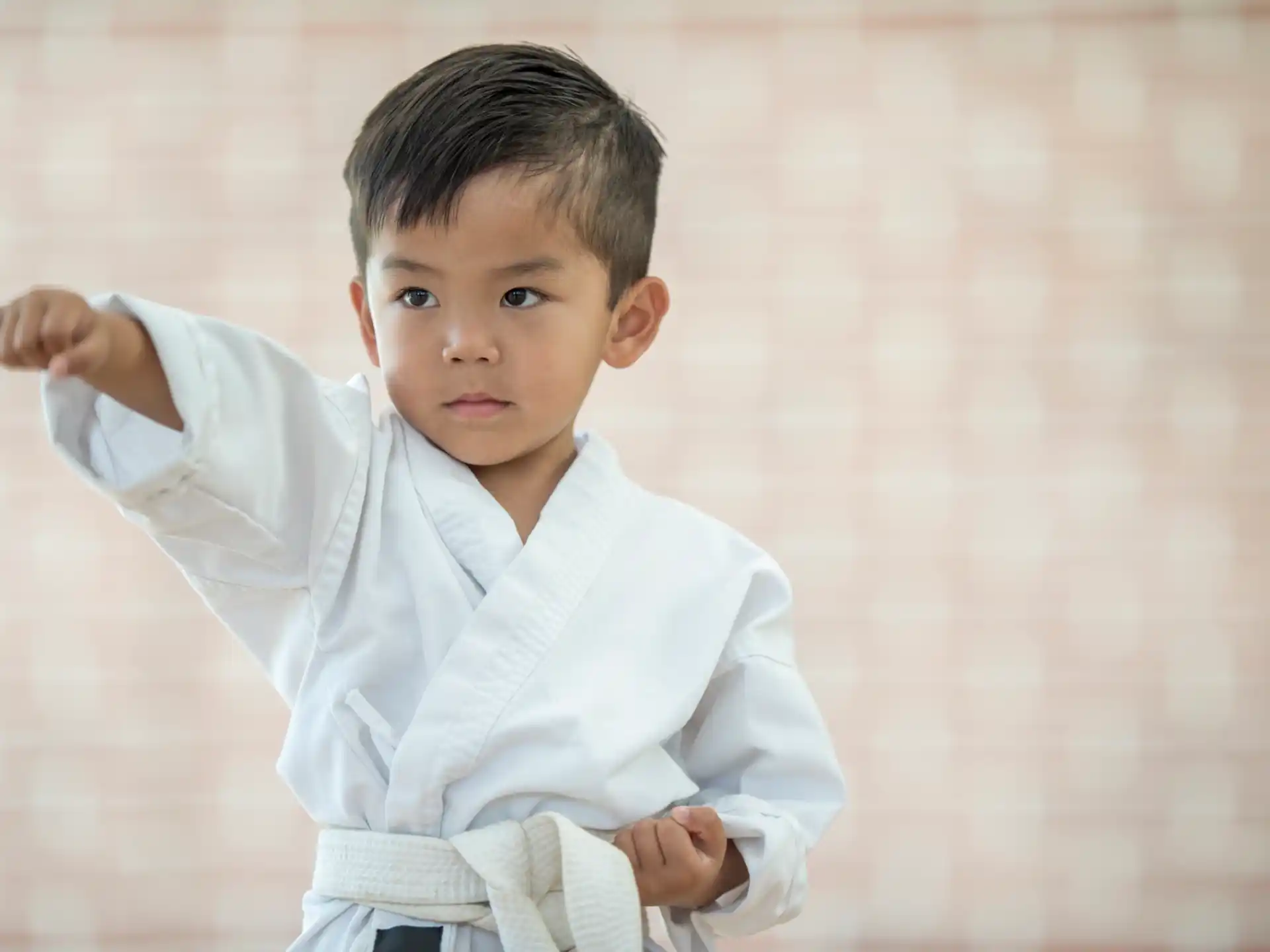 a young boy holding a white belt