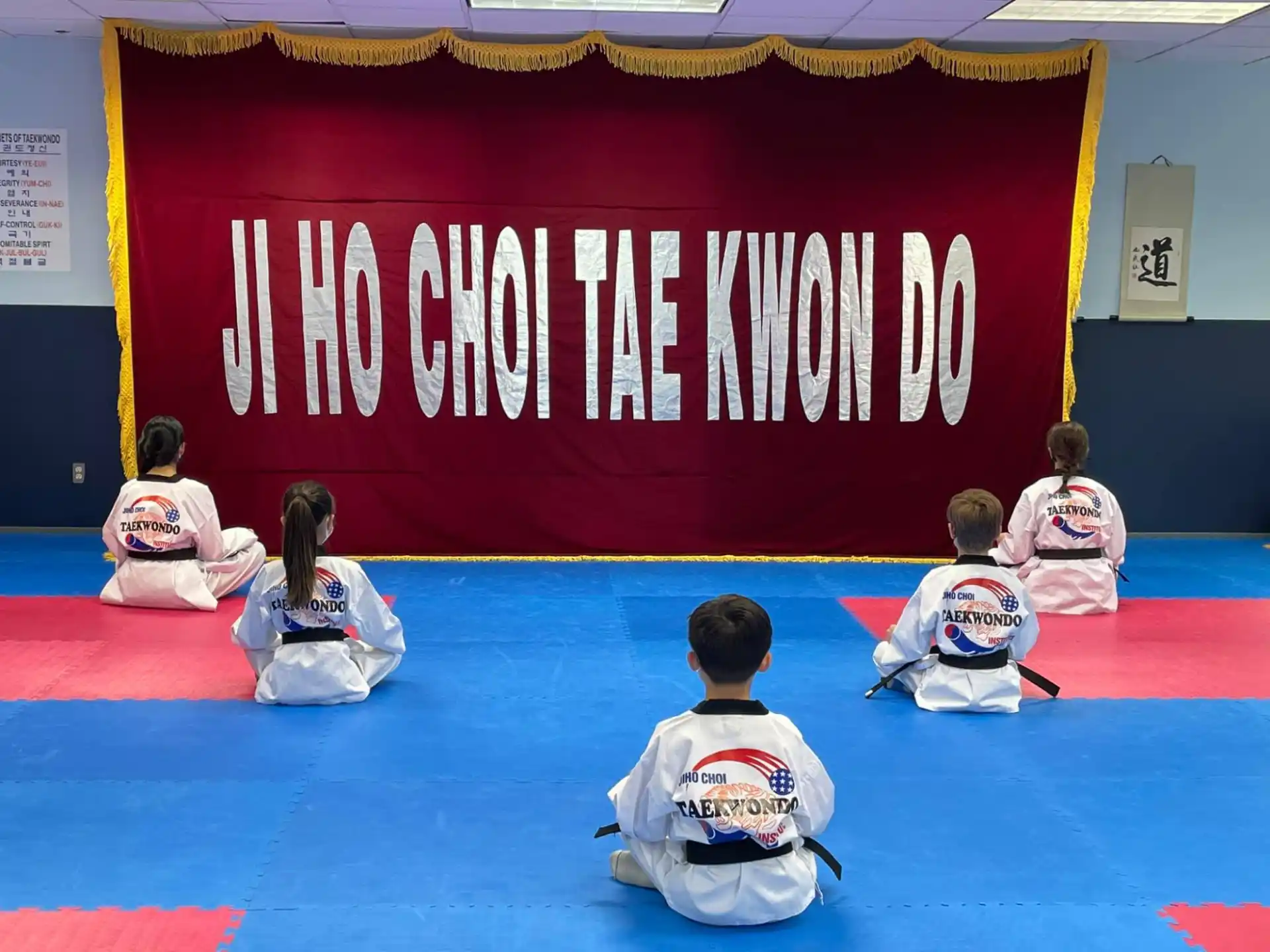 a group of people sitting on the floor in front of a banner