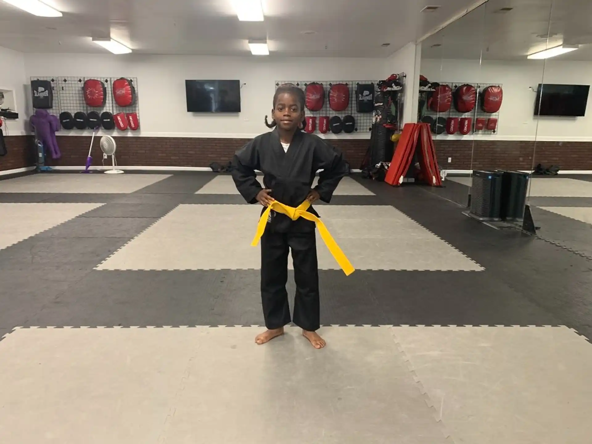 a person holding a yellow bow and arrow in a gym