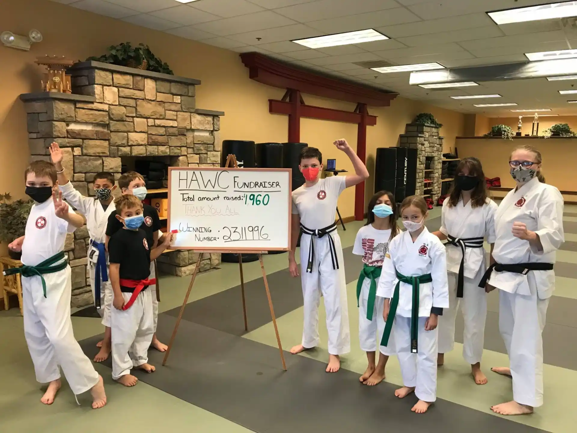 a group of people in karate uniforms holding a sign