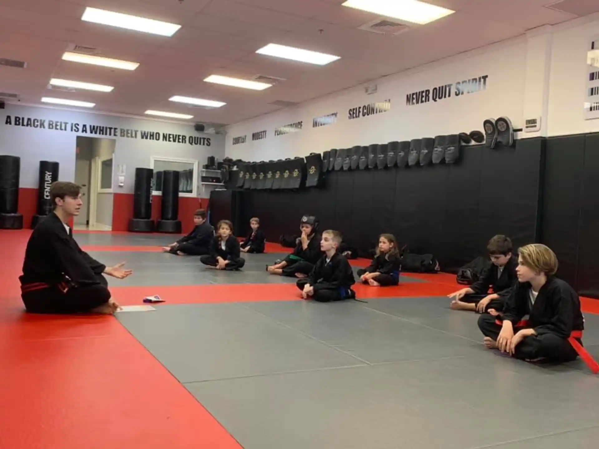 a group of people sitting on a mat in a room
