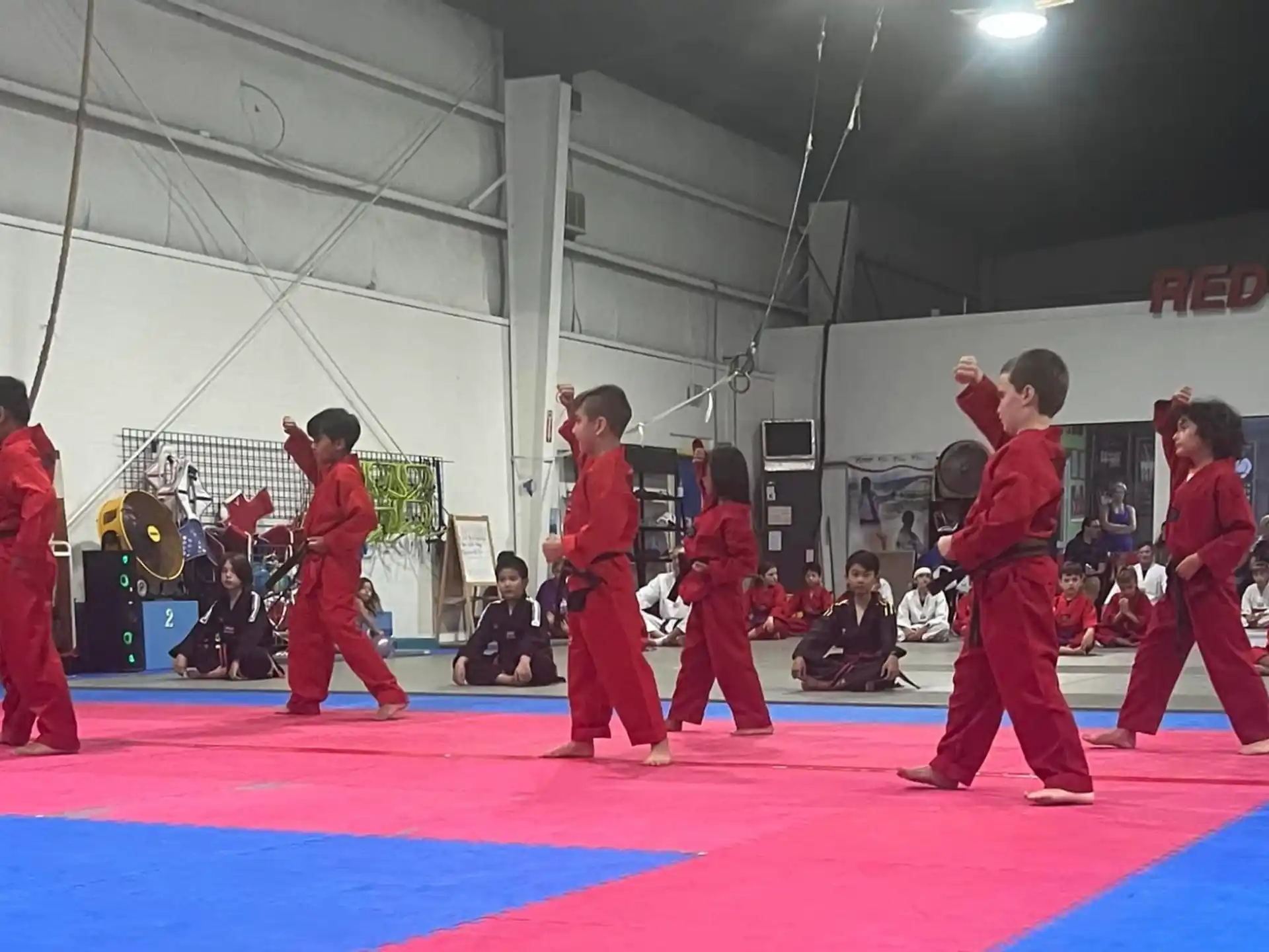 a group of people in red uniforms practicing martial arts