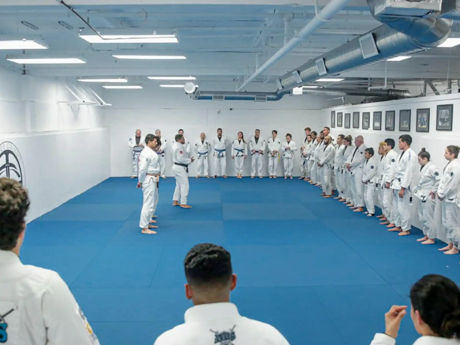 a group of people in white karate uniforms standing in a room