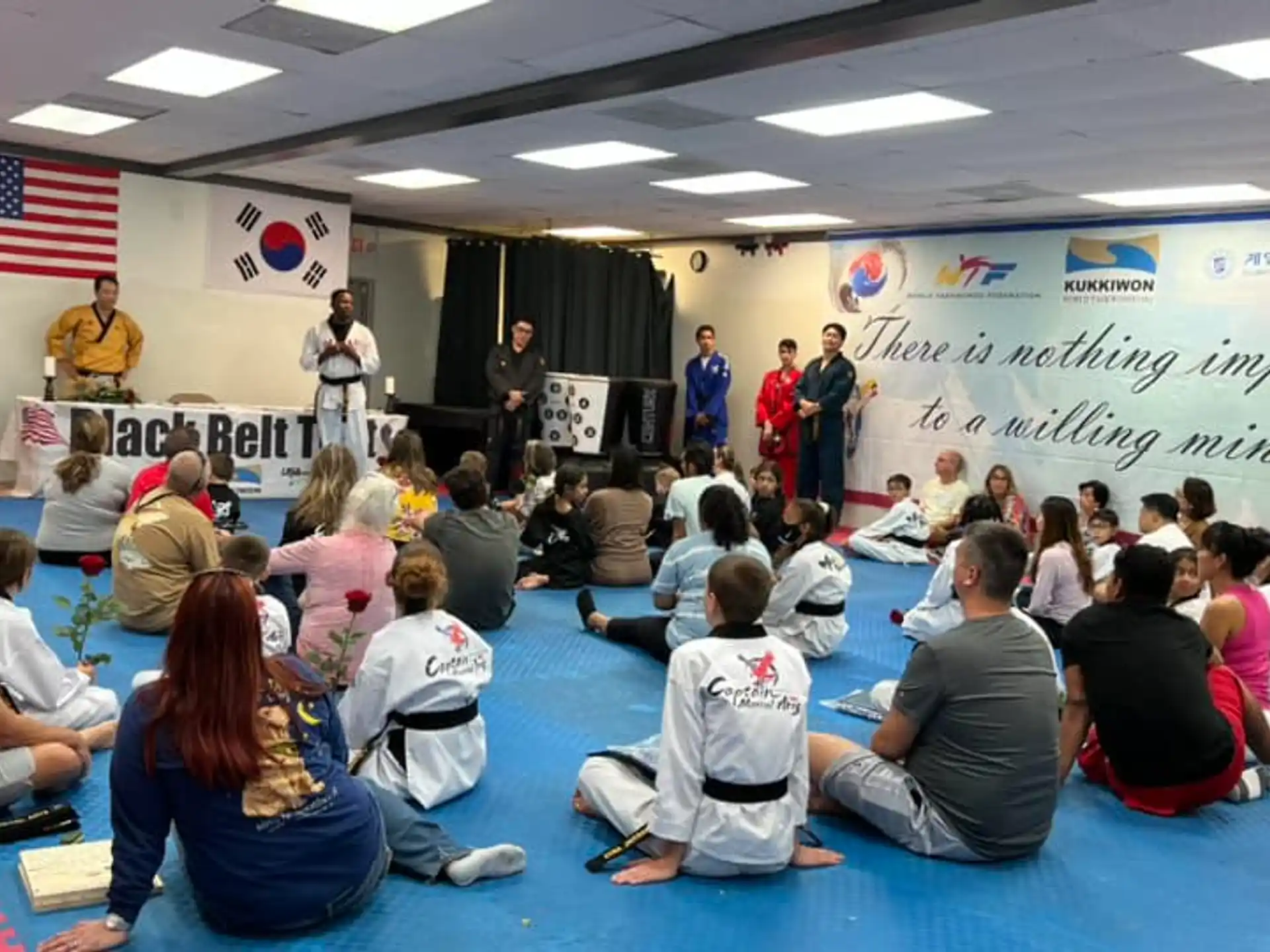 a group of people sitting in a room with a person standing in front of a podium