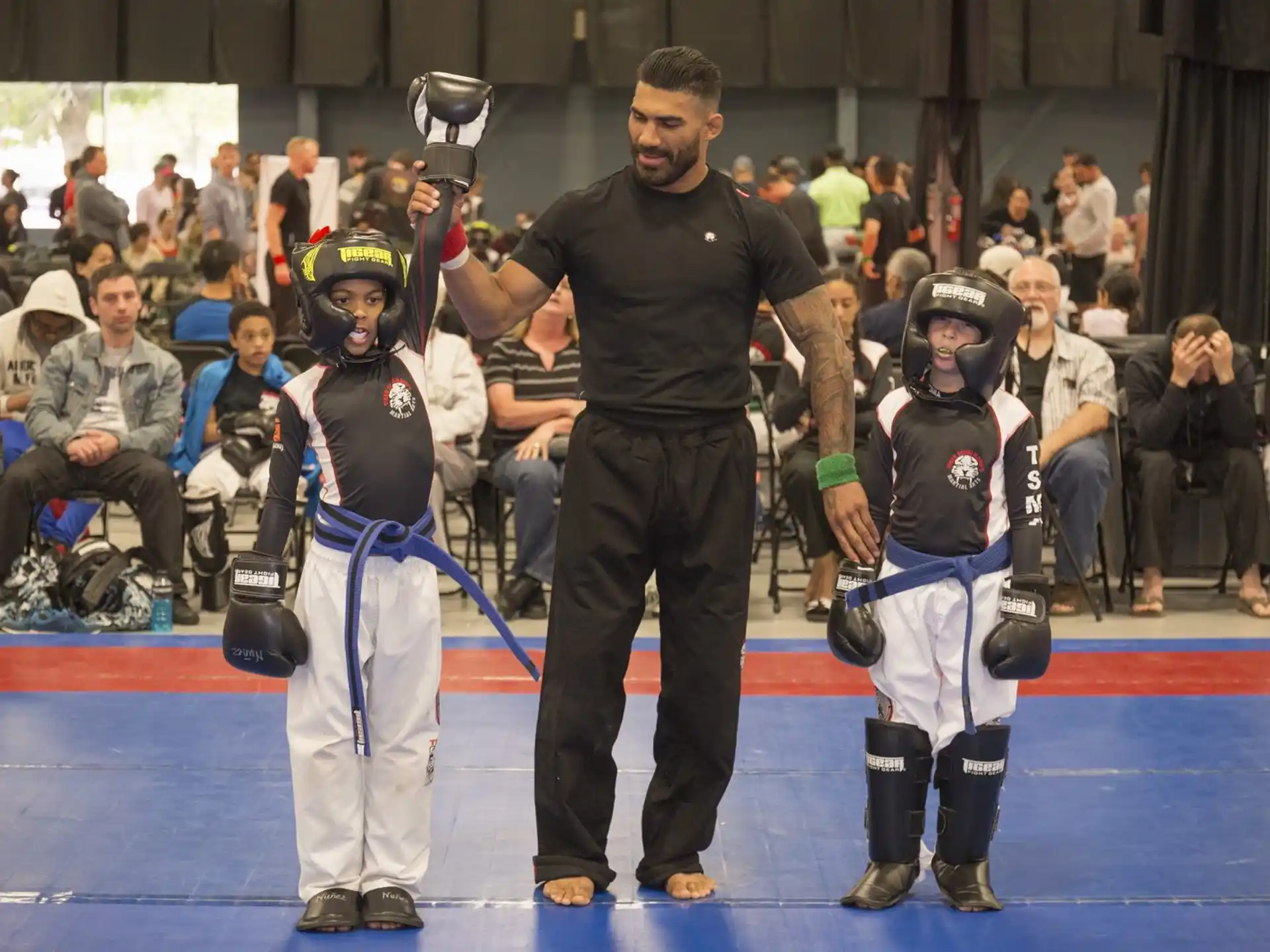 a person standing next to a group of people wearing helmets and holding swords