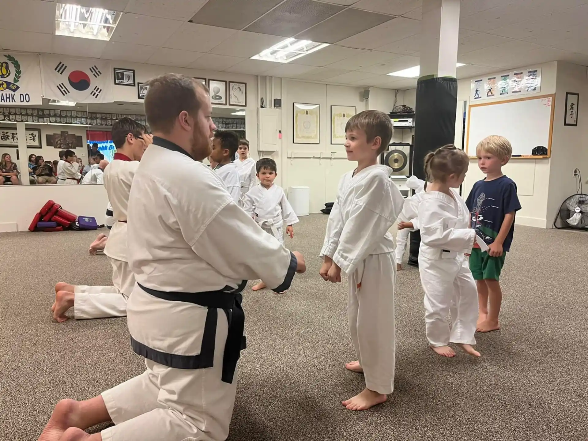 a person in a karate uniform with a group of children