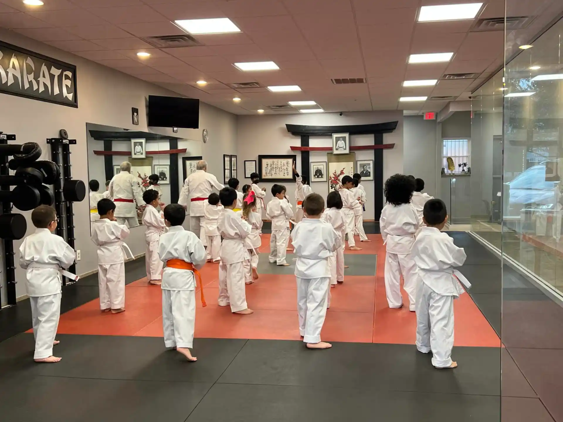 a group of people in white karate uniforms in a room