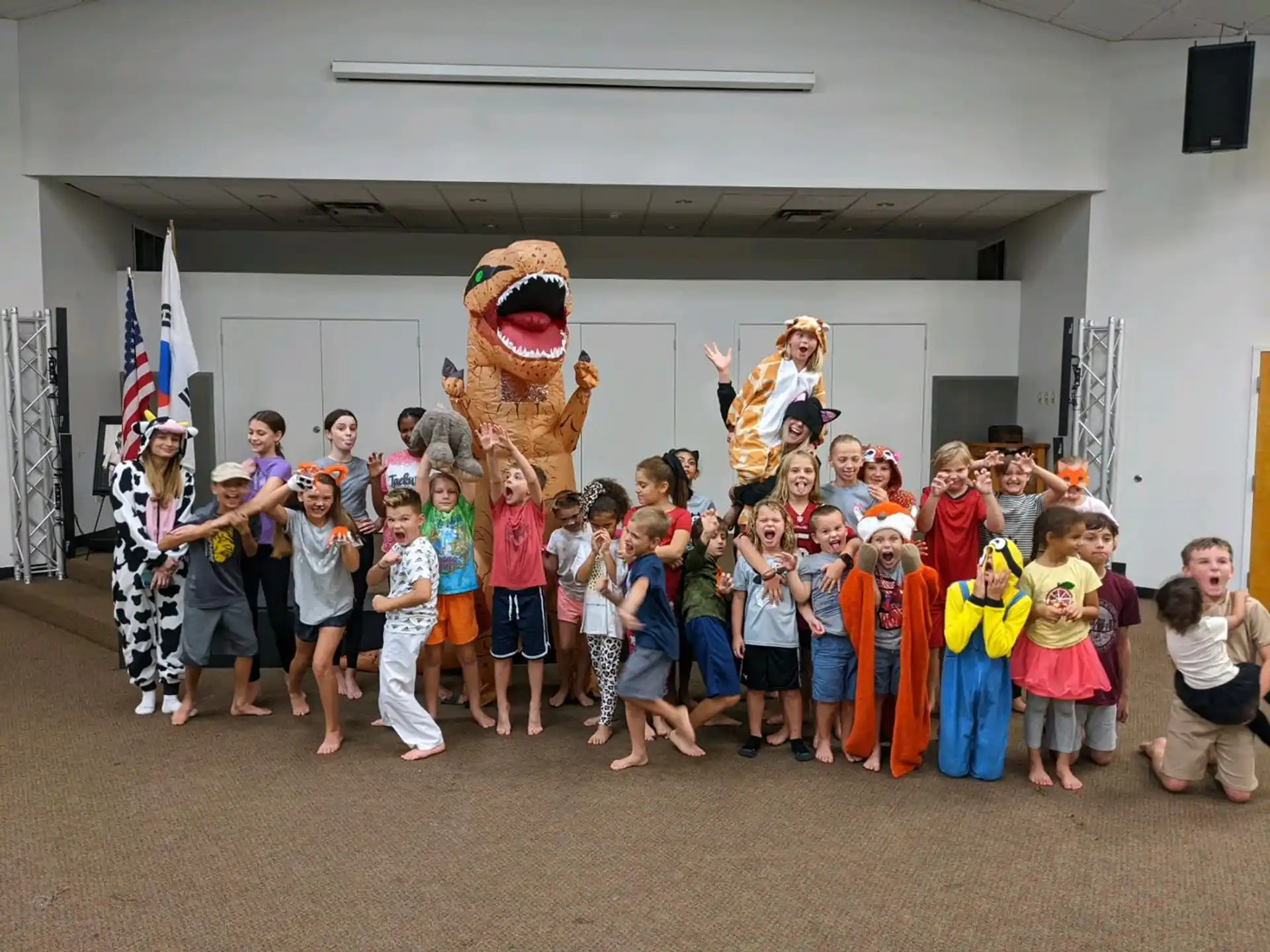 a group of children posing for a photo with a person in a garment