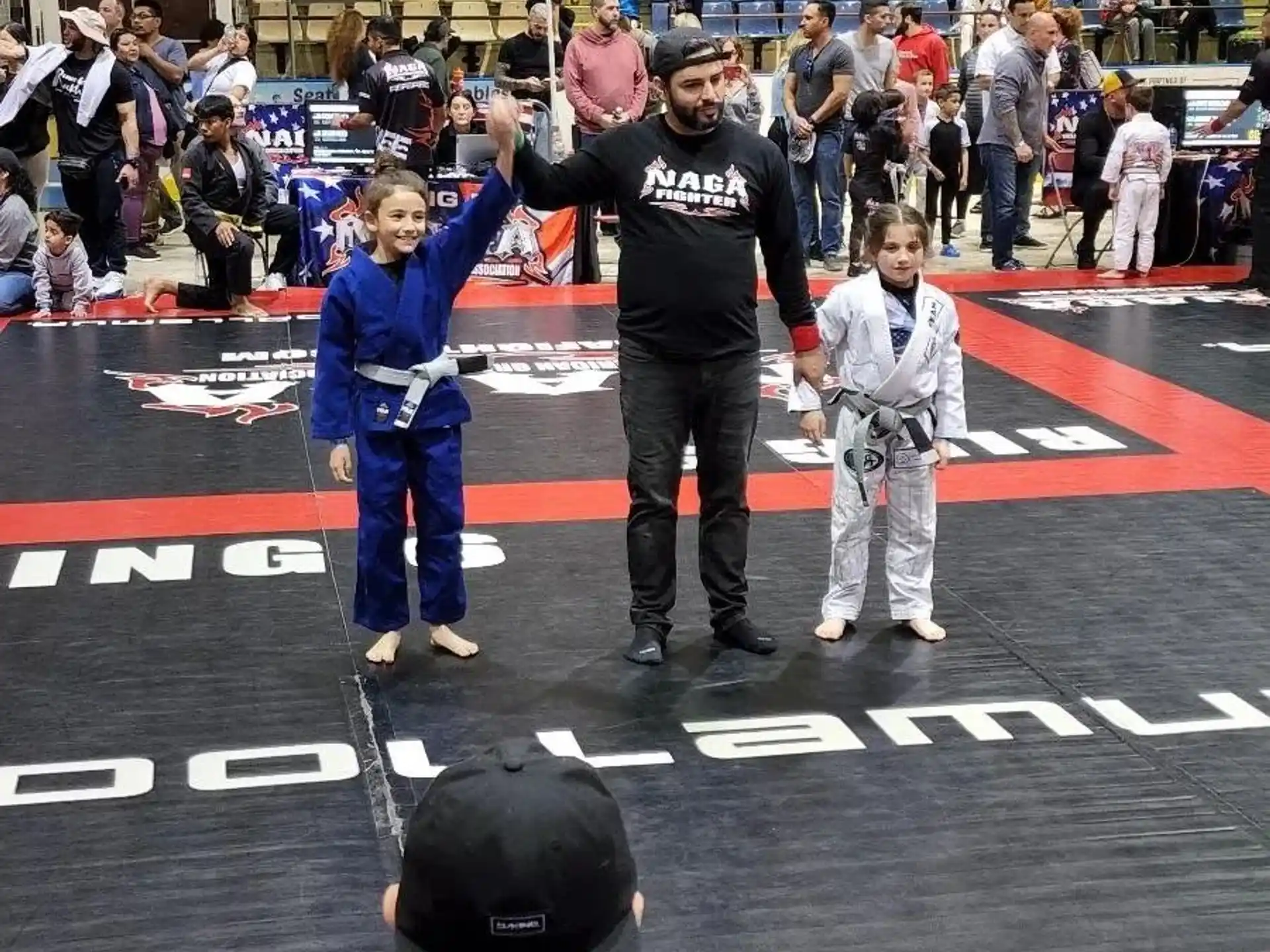 a person standing on a mat with a group of people in the back