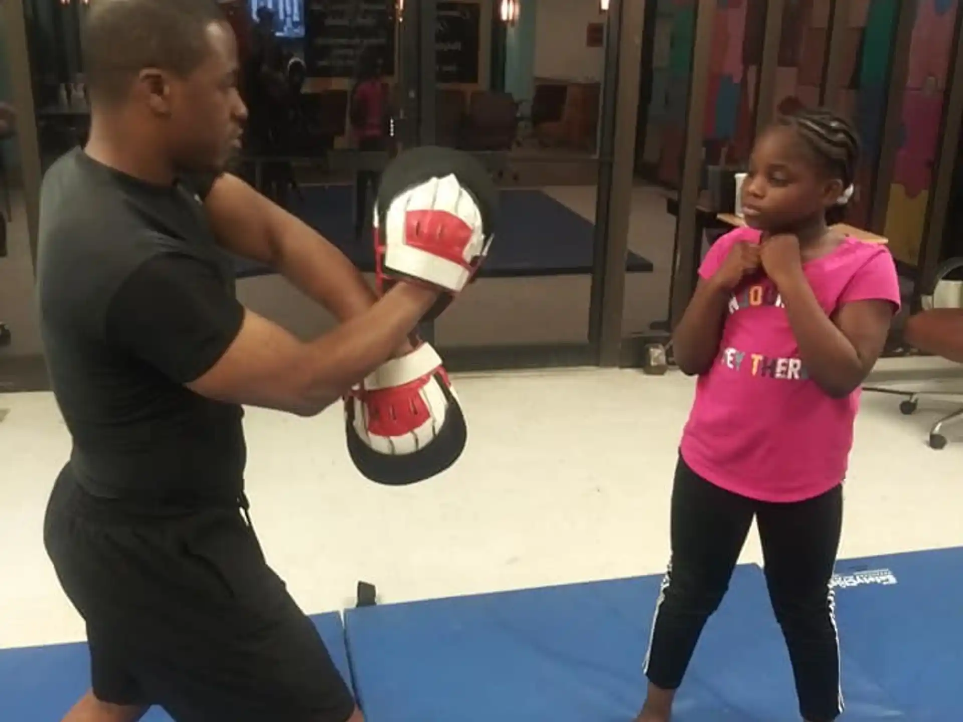 a person and a girl playing with a ball in a gym