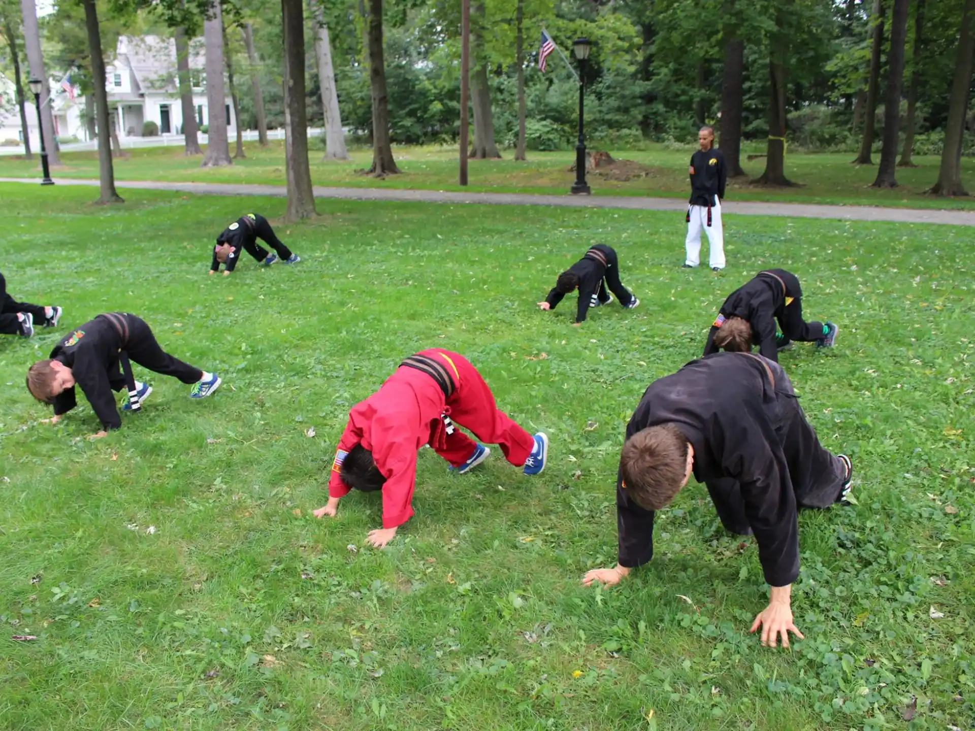 a group of people doing push ups in a park