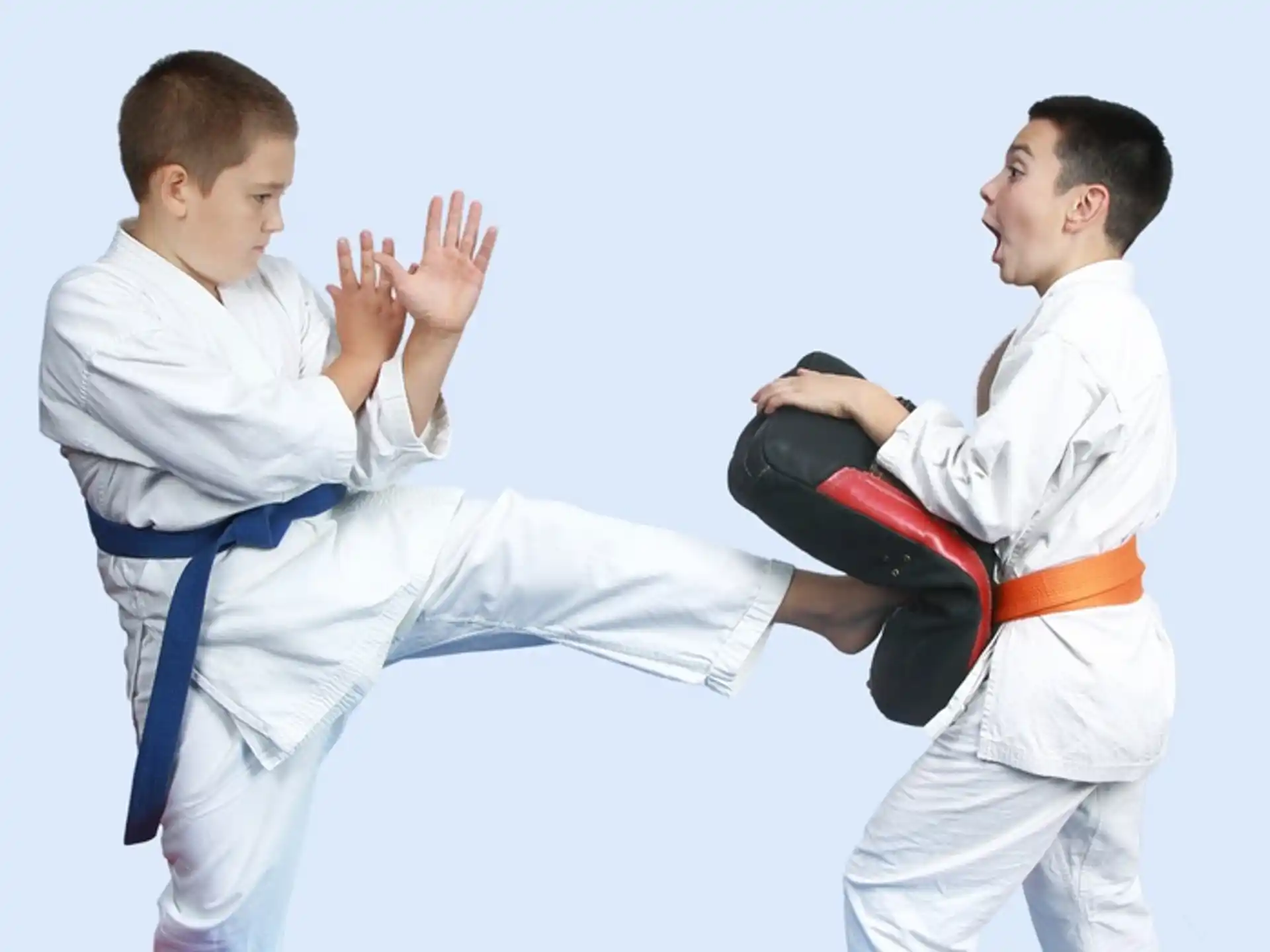 a man in a karate uniform kicking another man in the face