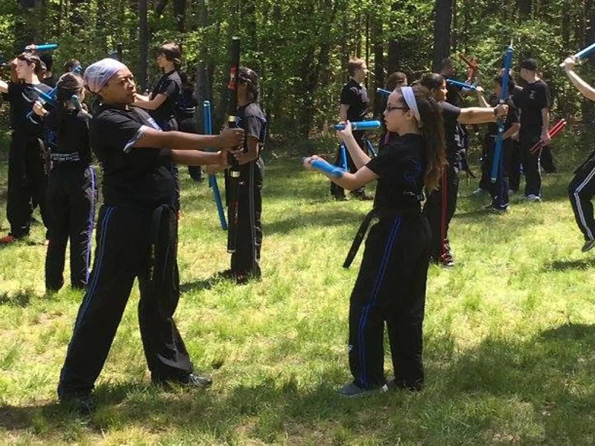 a group of people in black and blue outfits holding swords