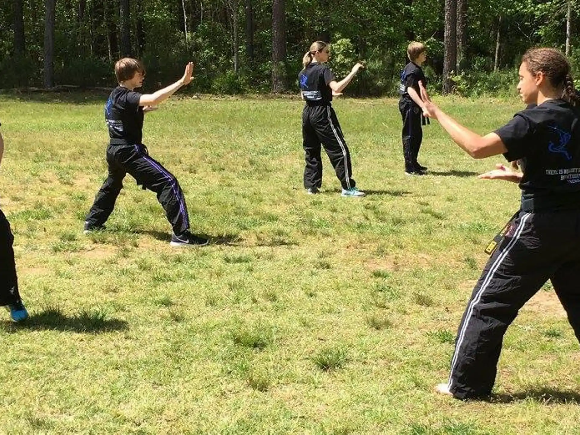 a group of people in black uniforms running on grass