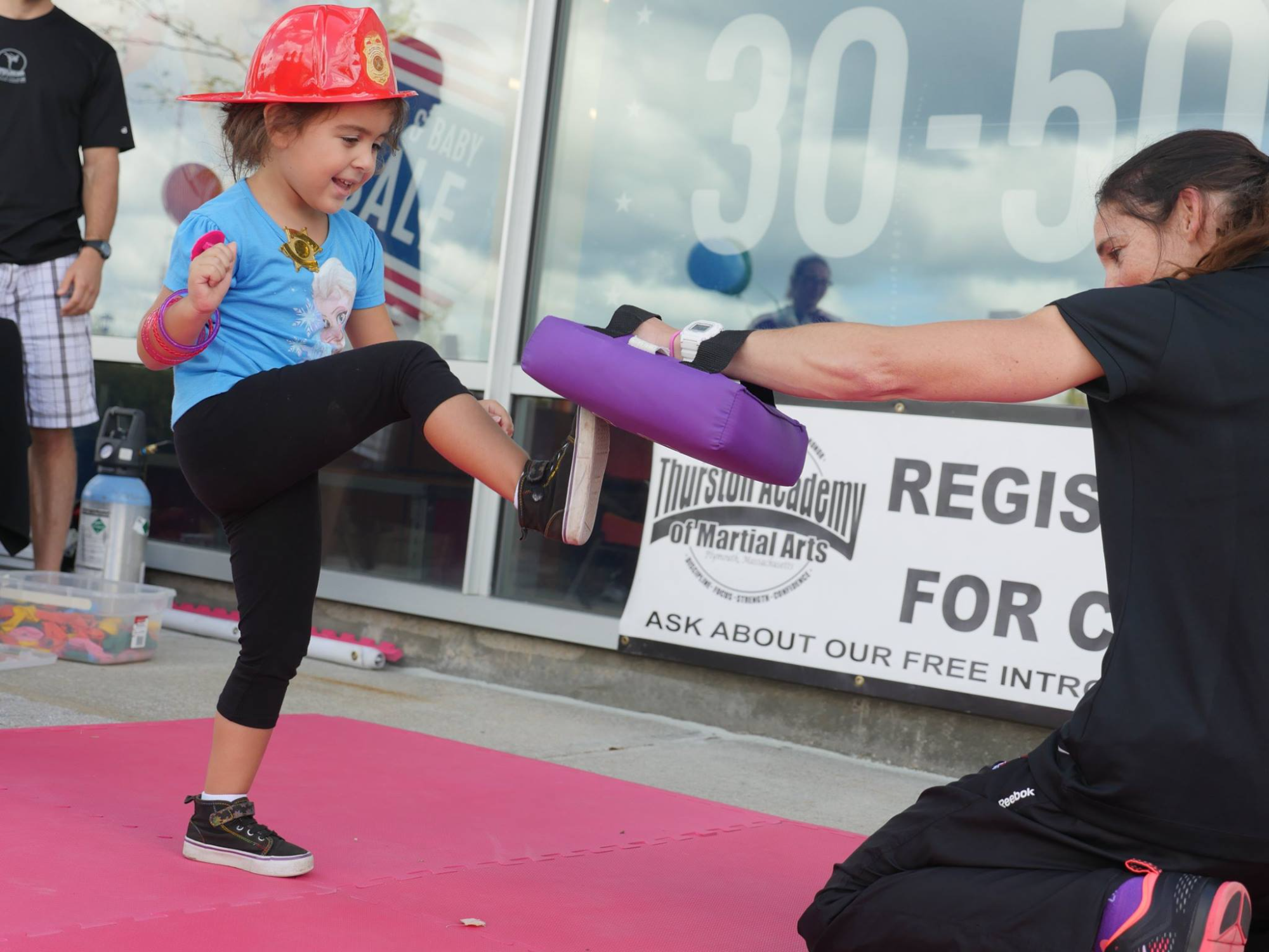 a person in a helmet holding a purple object next to a person