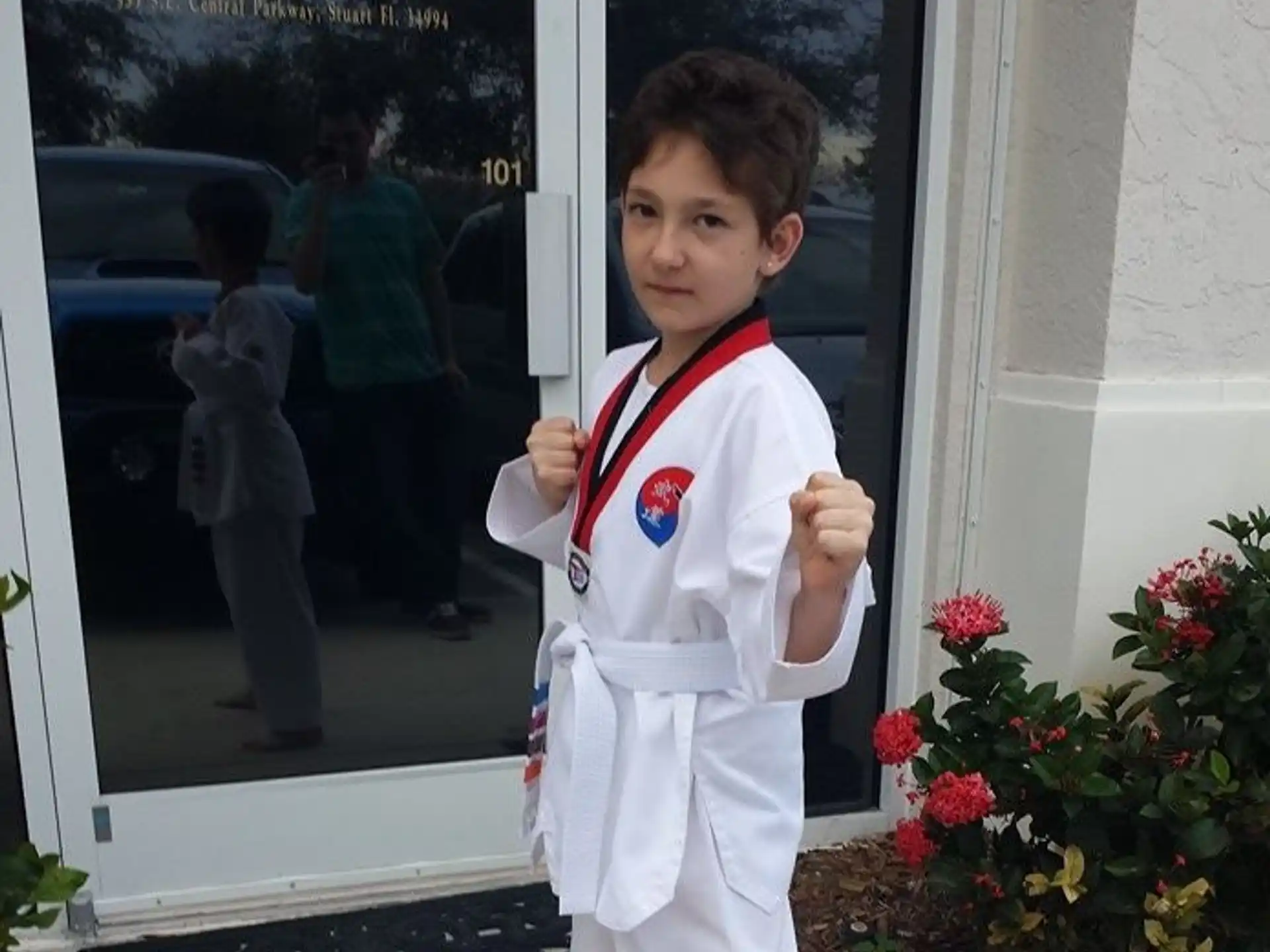 a young boy wearing a white uniform