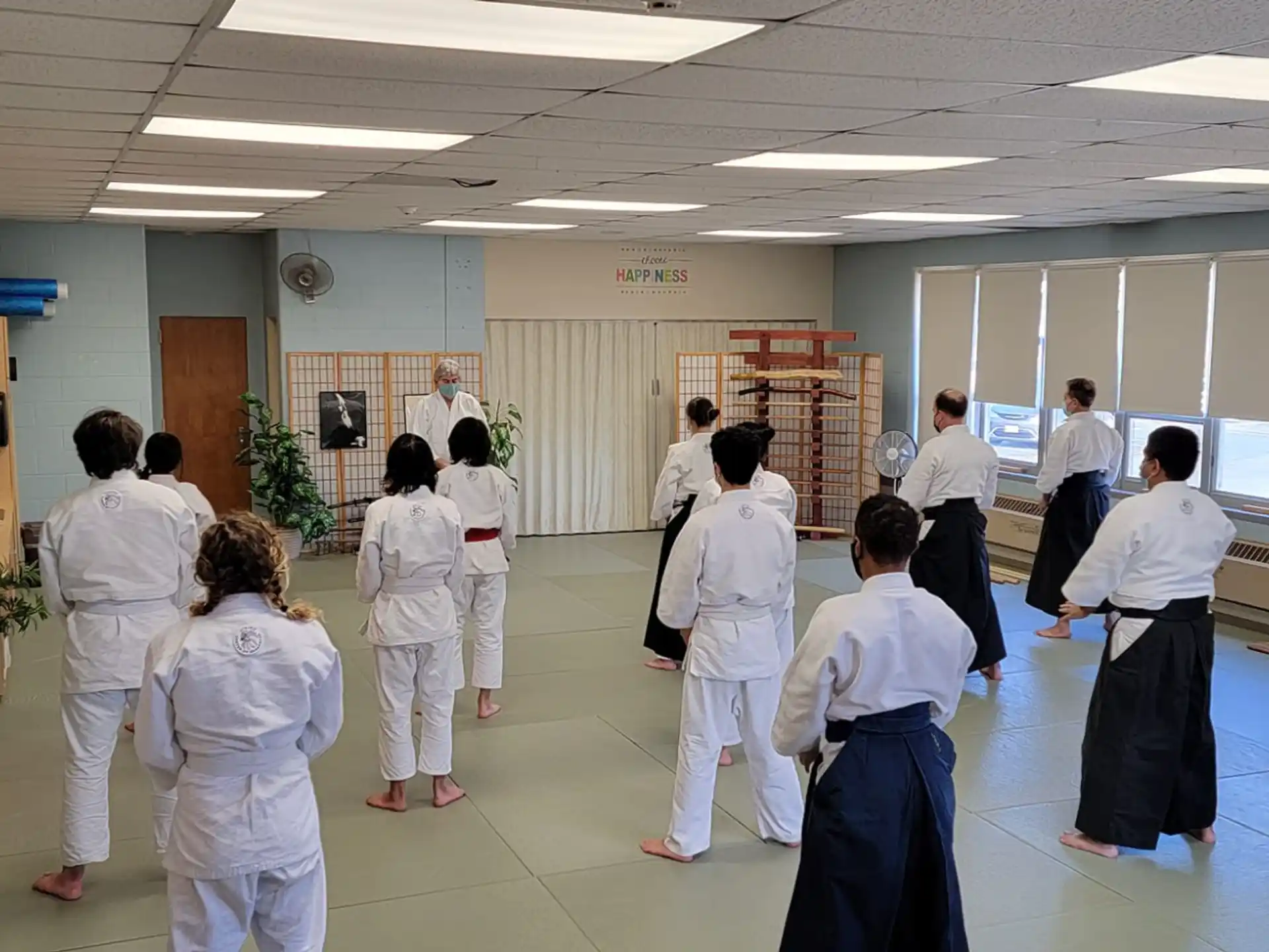 a group of people in white karate uniforms in a room