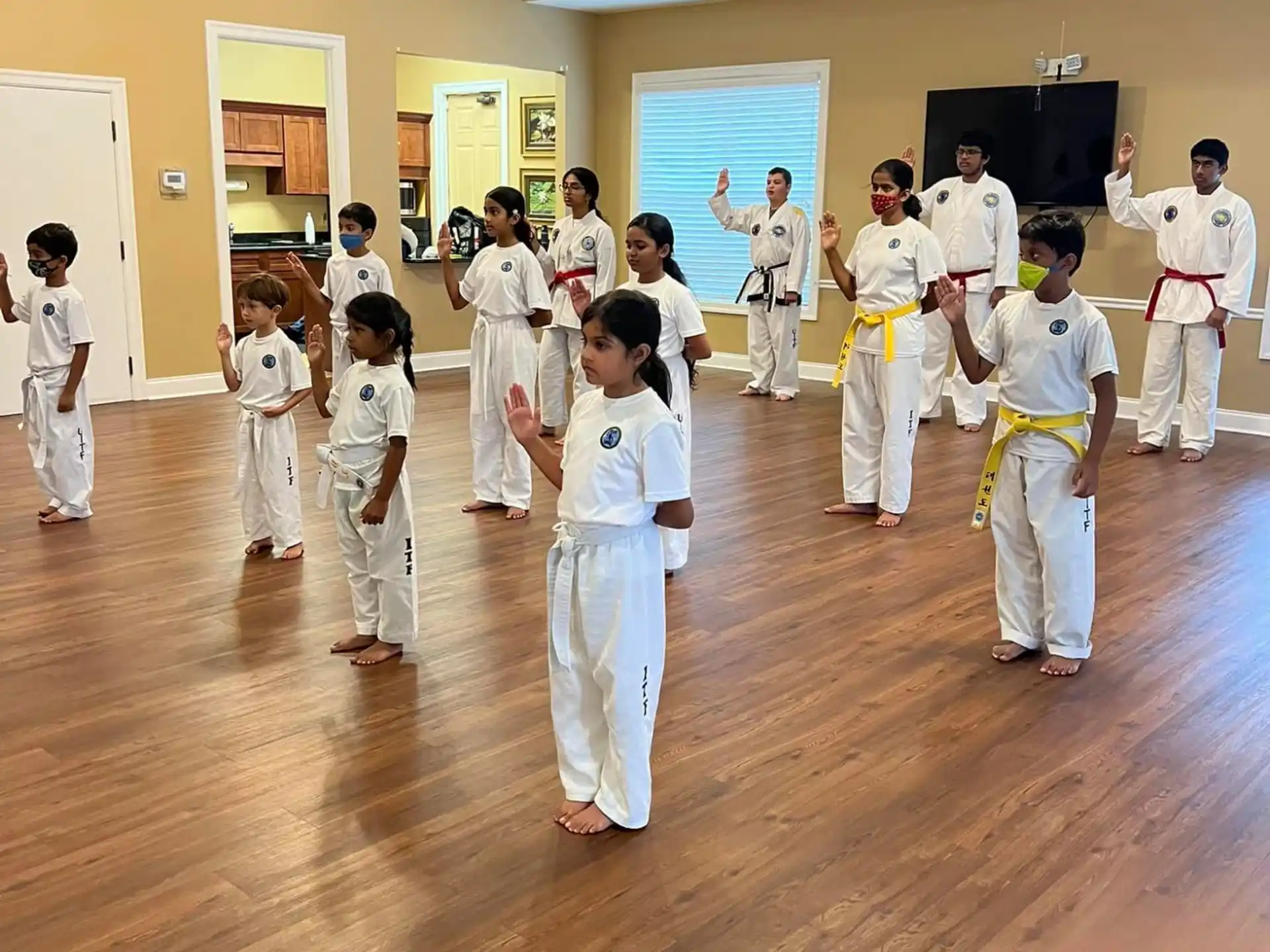 a group of people in white karate uniforms in a room
